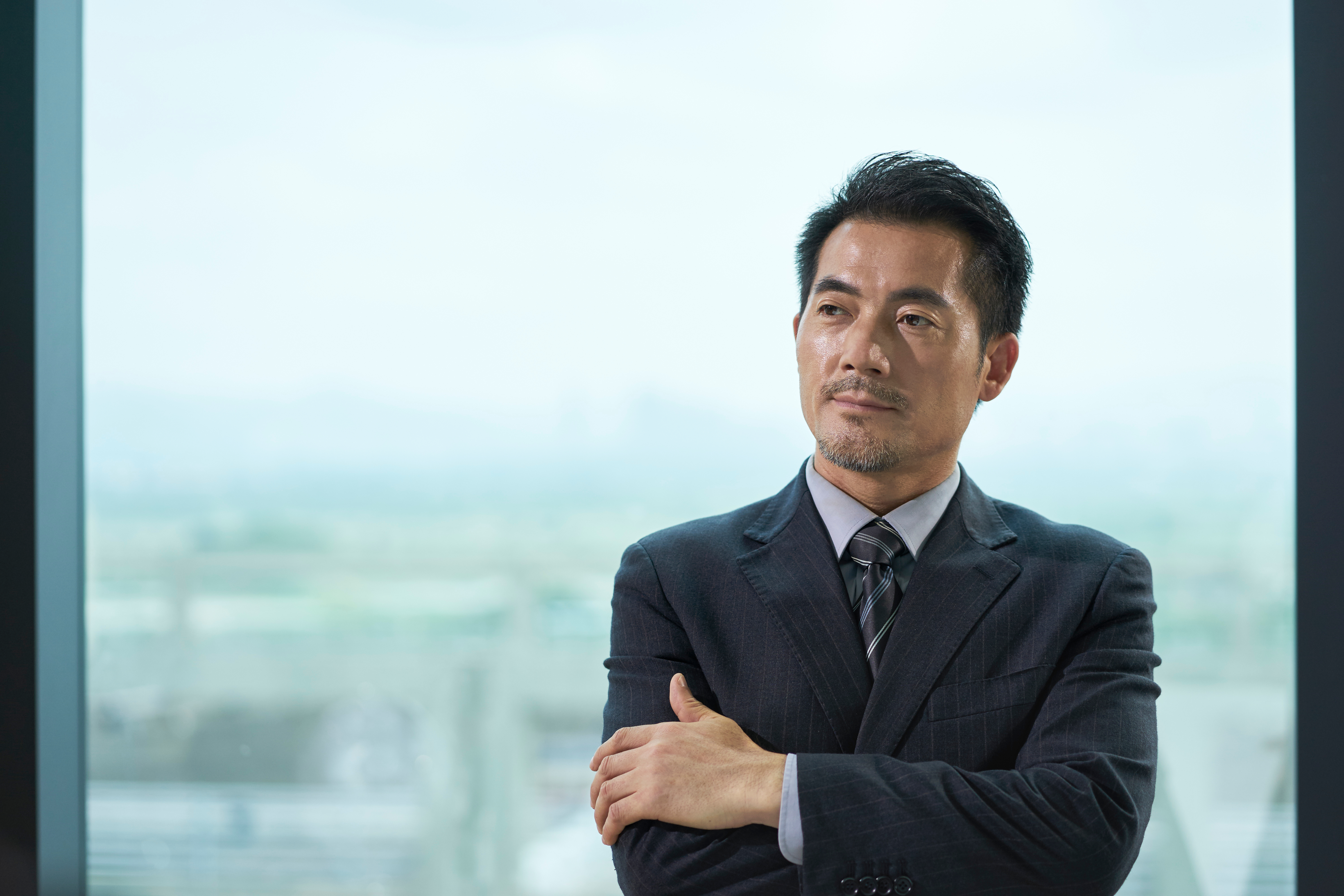 Korean businessman standing in his office | Source: Shutterstock