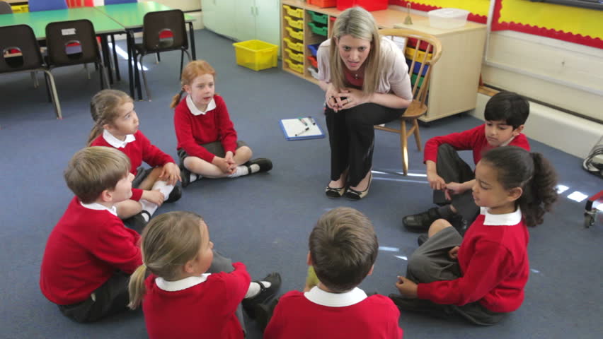 Teacher talking to pupils in an elementary class | Shutterstock.com