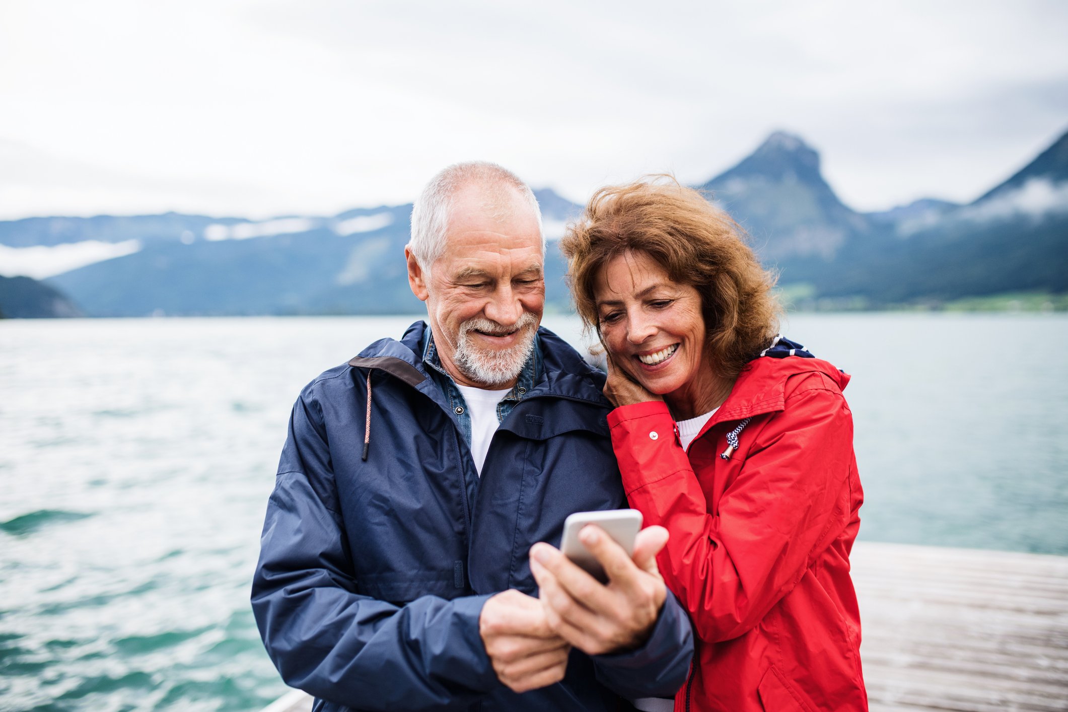 Un couple au bord d'un lac regardant un smartphone. | Photo : Getty Images
