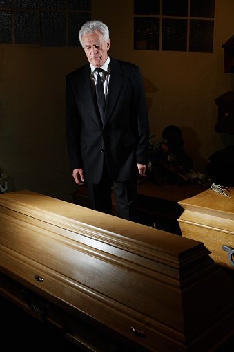 Photo of a man standing in a funeral parlor | Photo: Getty Images