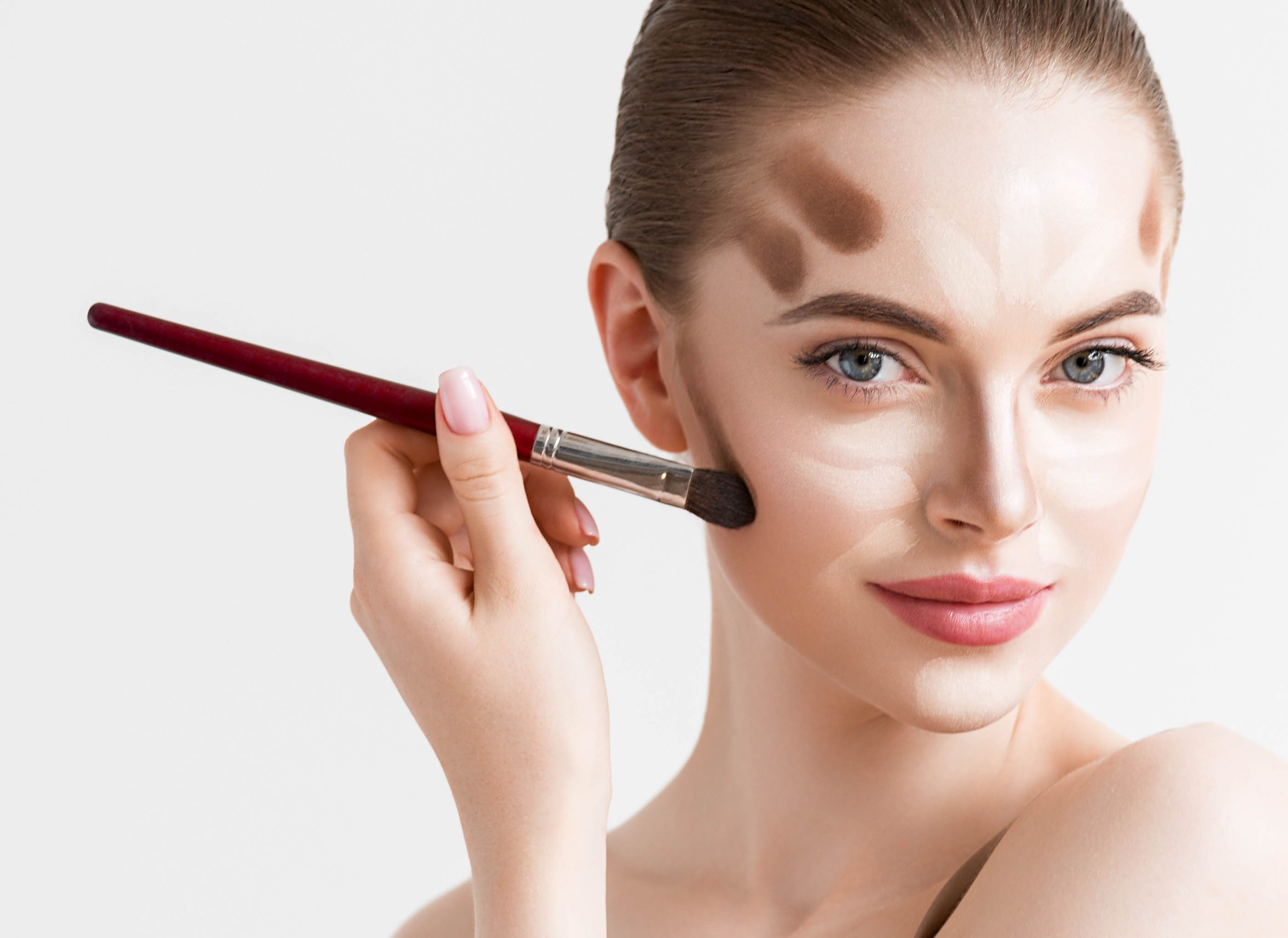 Modelo aplicando contornos en su rostro. | Foto: Shutterstock