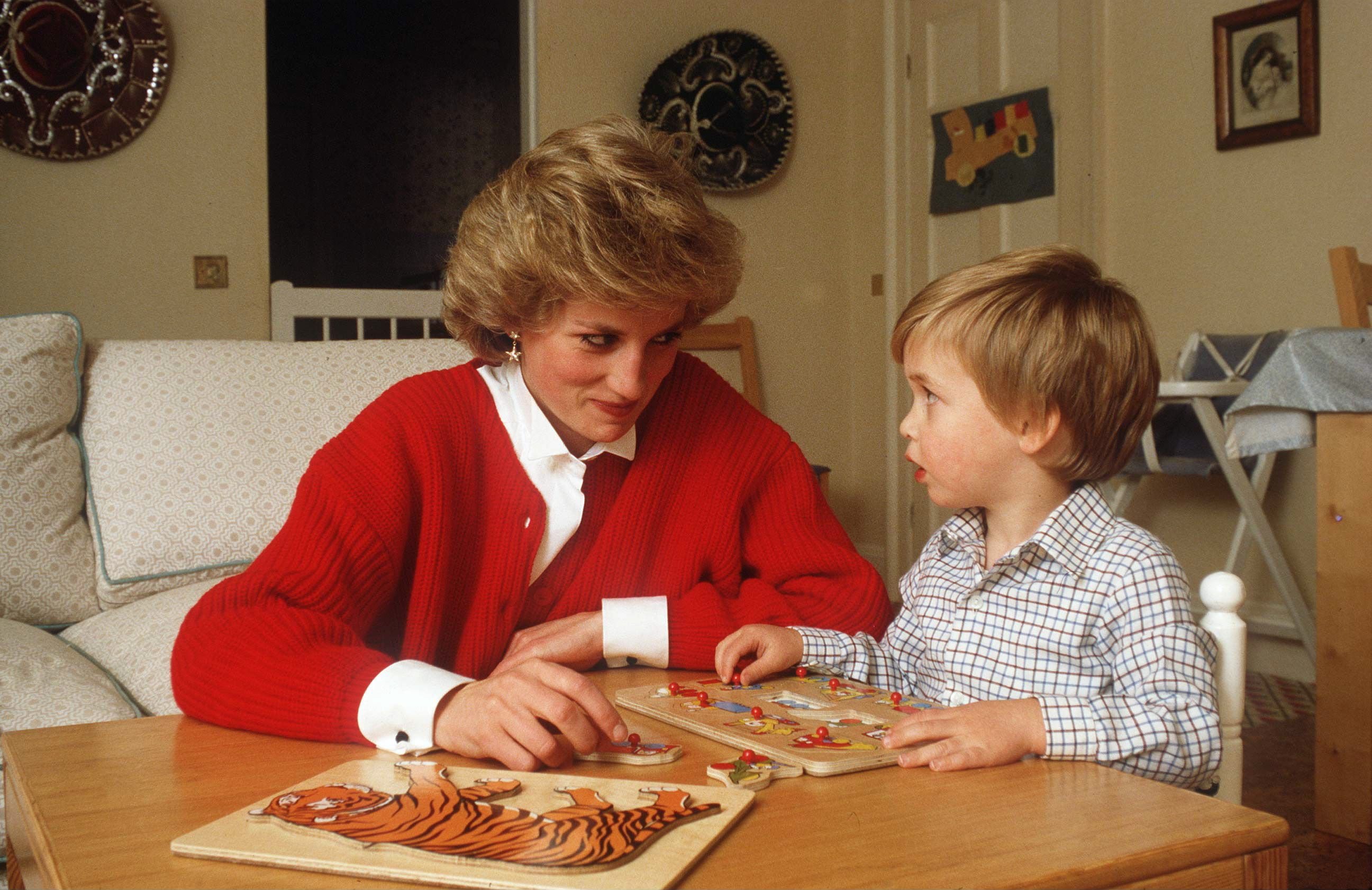 La princesa Diana ayudando al príncipe William con un juguete de rompecabezas en su sala de juegos en casa en el Palacio de Kensington. | Foto: Getty Images