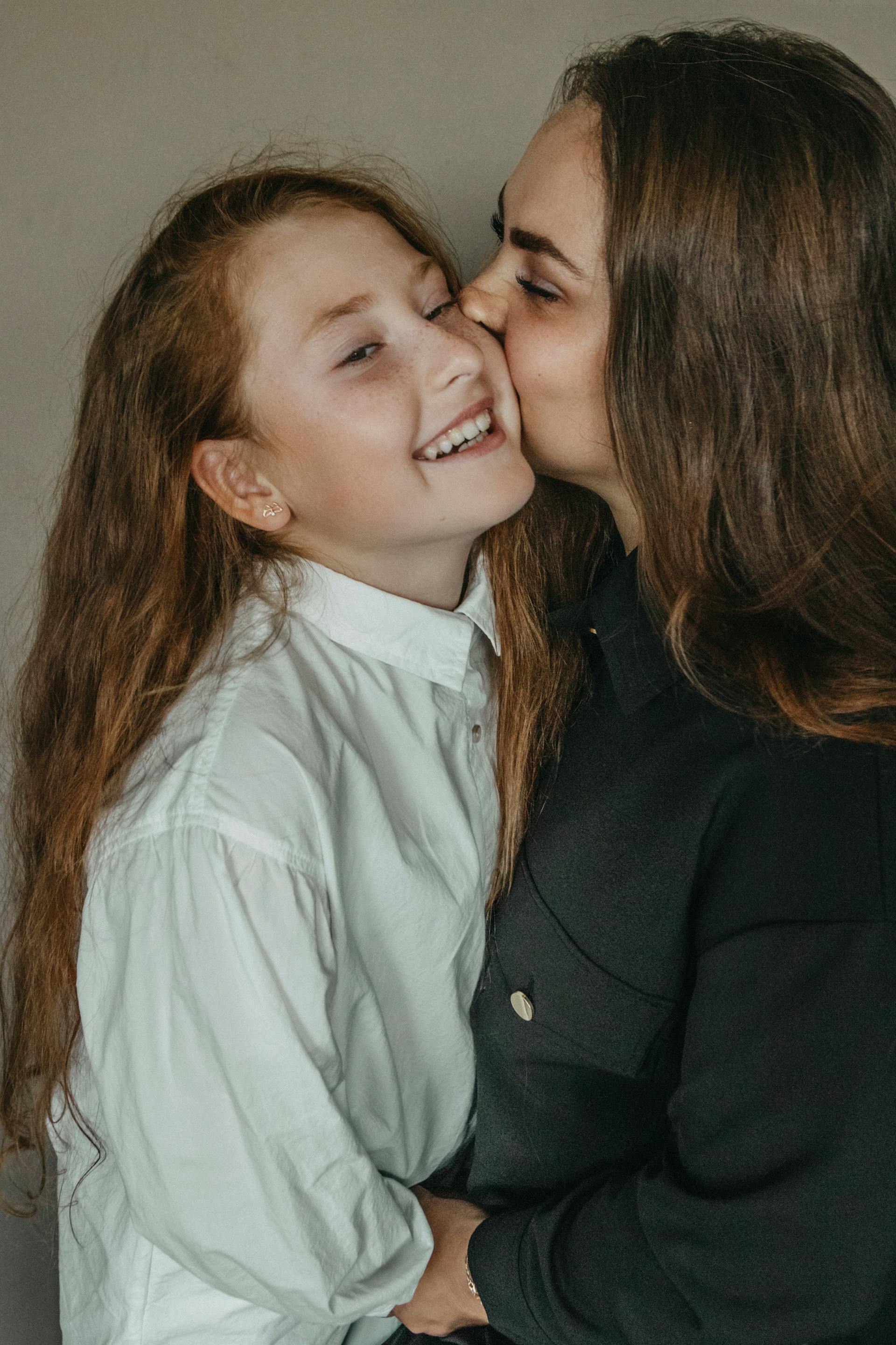 A woman kissing her young daughter | Source: Pexels