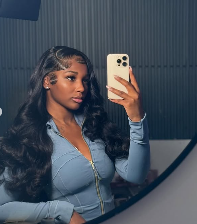 Ashly Robinson captures her reflection with effortless poise, her softly curled hair and fitted blue zip-up creating a look that feels both polished and quietly confident. | Source: Instagram/ashleejenae