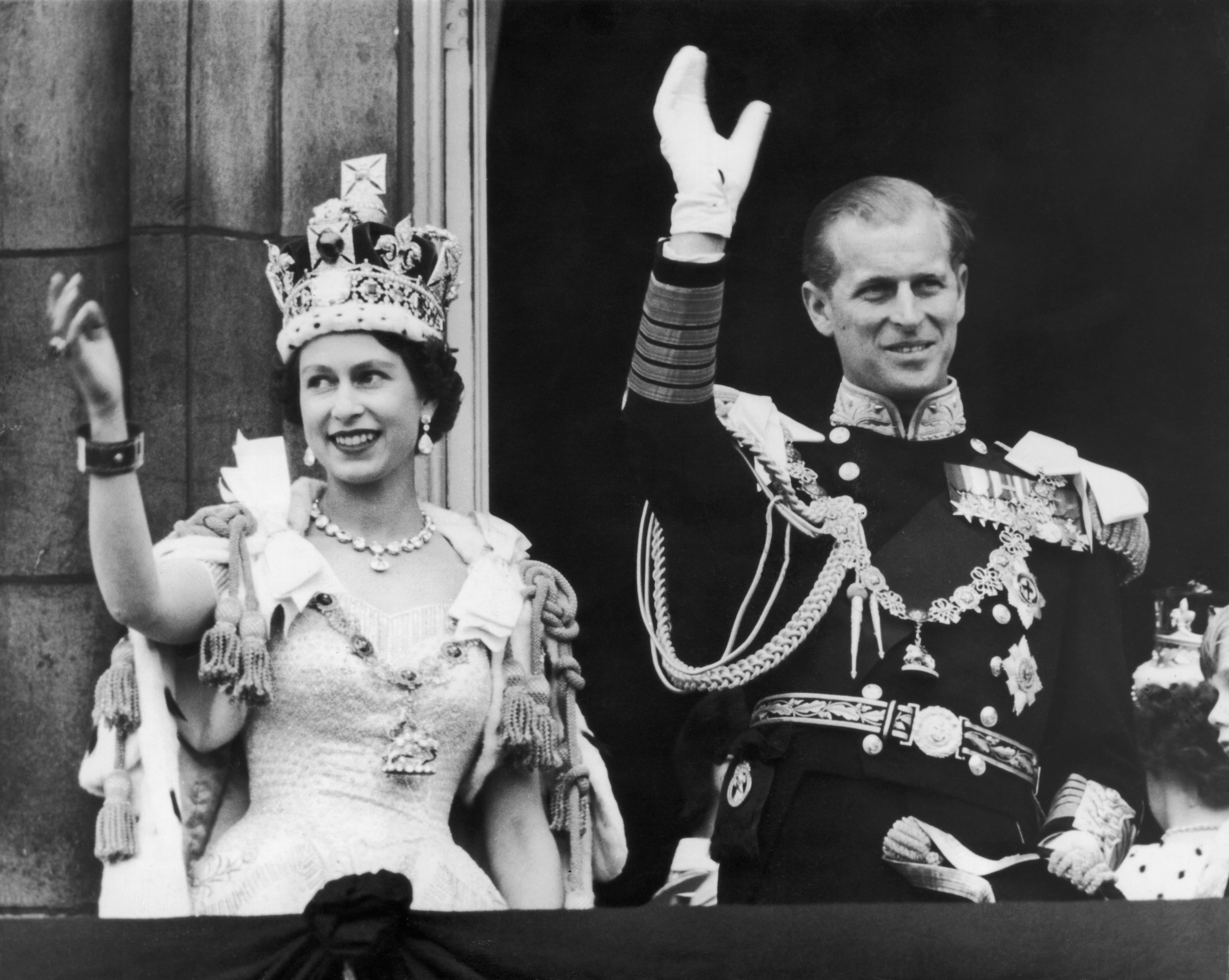 Queen Elizabeth II and the Duke of Edinburgh wave at the crowds from the balcony at Buckingham Palace after Elizabeth's coronation, 2nd June 1953. | Source: Getty Images