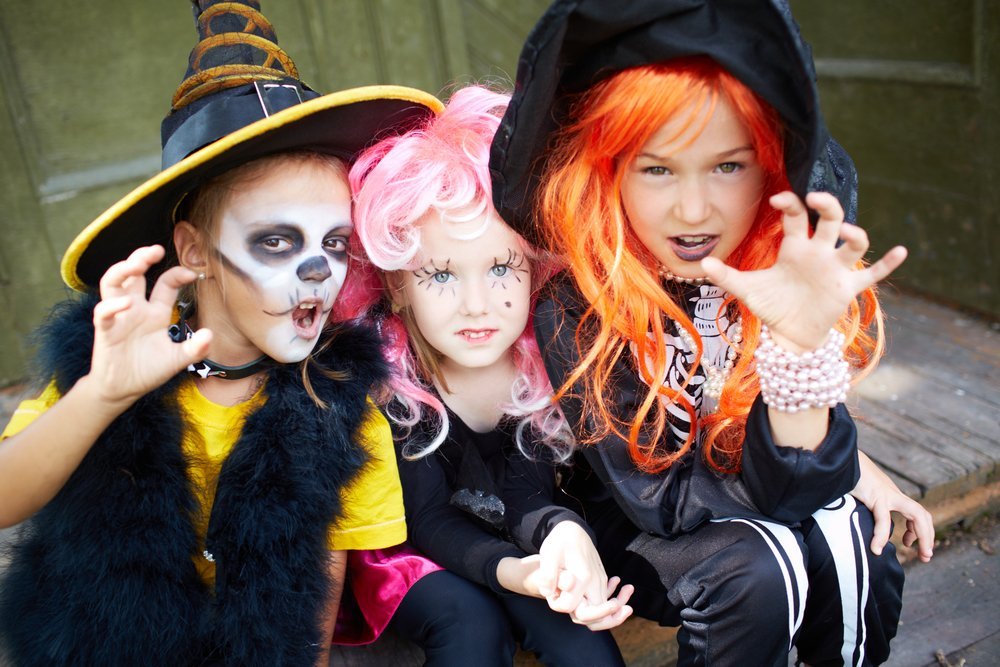 Three girls in Halloween costumes make gesture | Photo: Shutterstock