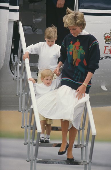 Princesse Diana arrive à l'aéroport d'Aberdeen avec ses fils William et Harry. | Photo: Getty Images