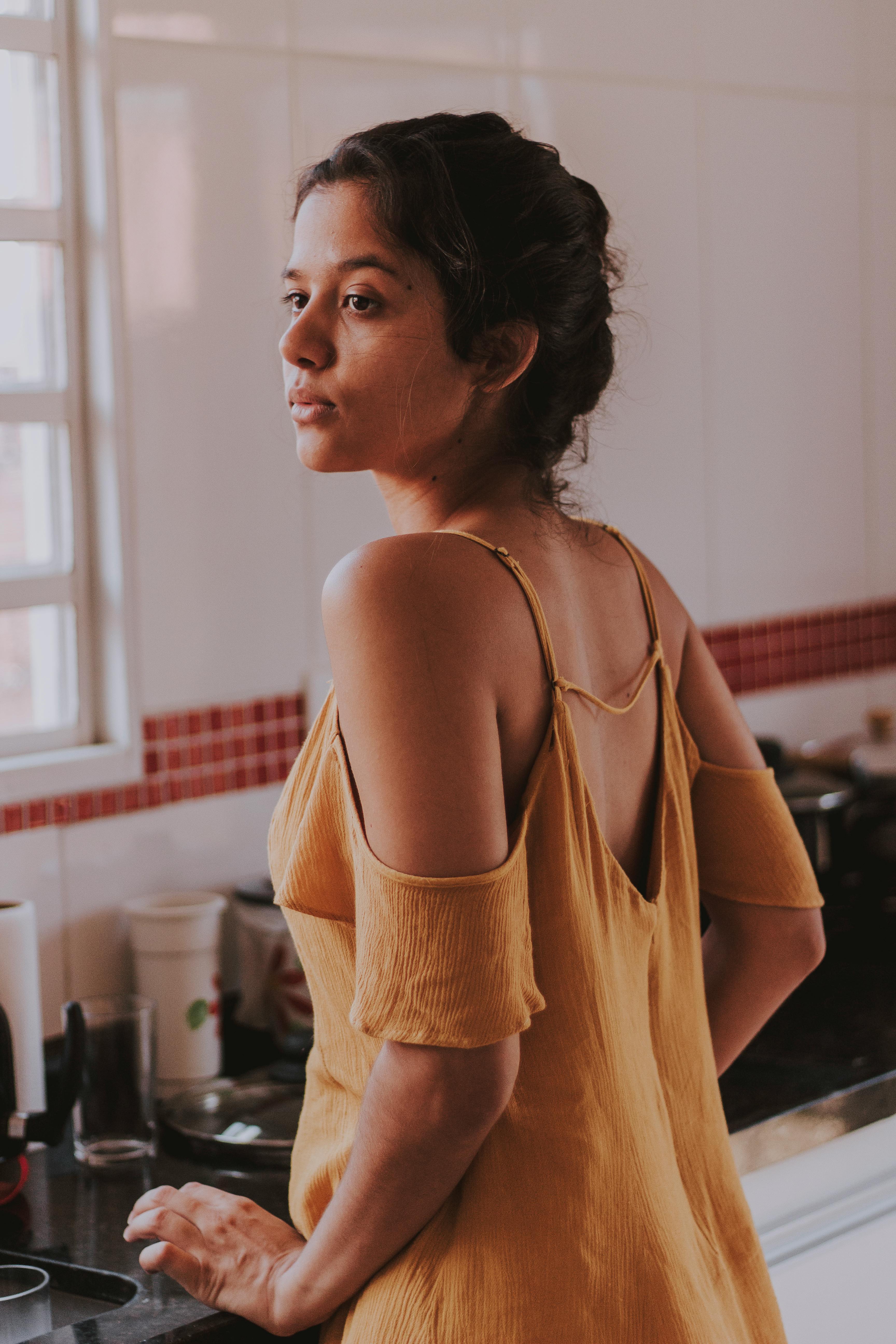 A woman looking upset while standing in the kitchen | Source: Pexels