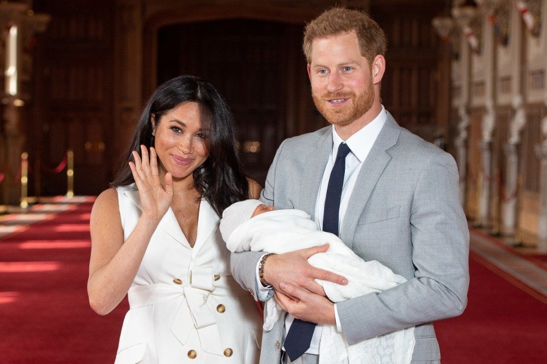 Britain's Prince Harry, Duke of Sussex, and his wife Meghan, Duchess of Sussex, pose for a photo with their newborn baby son, Archie Harrison Mountbatten-Windsor, in St George's Hall at Windsor Castle in Windsor, west of London on May 8, 2019. | Source: Getty Images