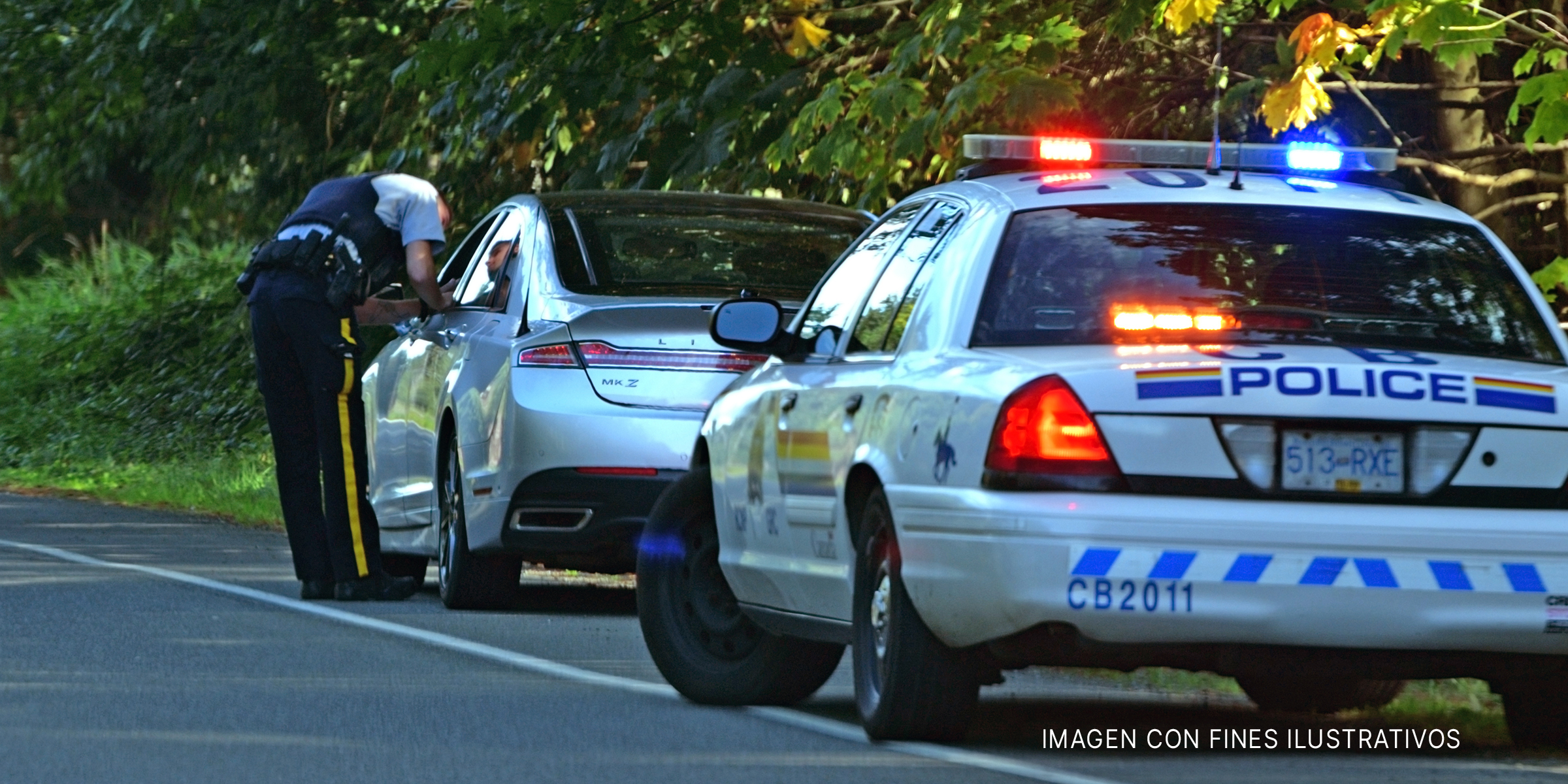 Policía hablando con el conductor de un vehículo a través de su ventanilla abierta. | Shutterstock