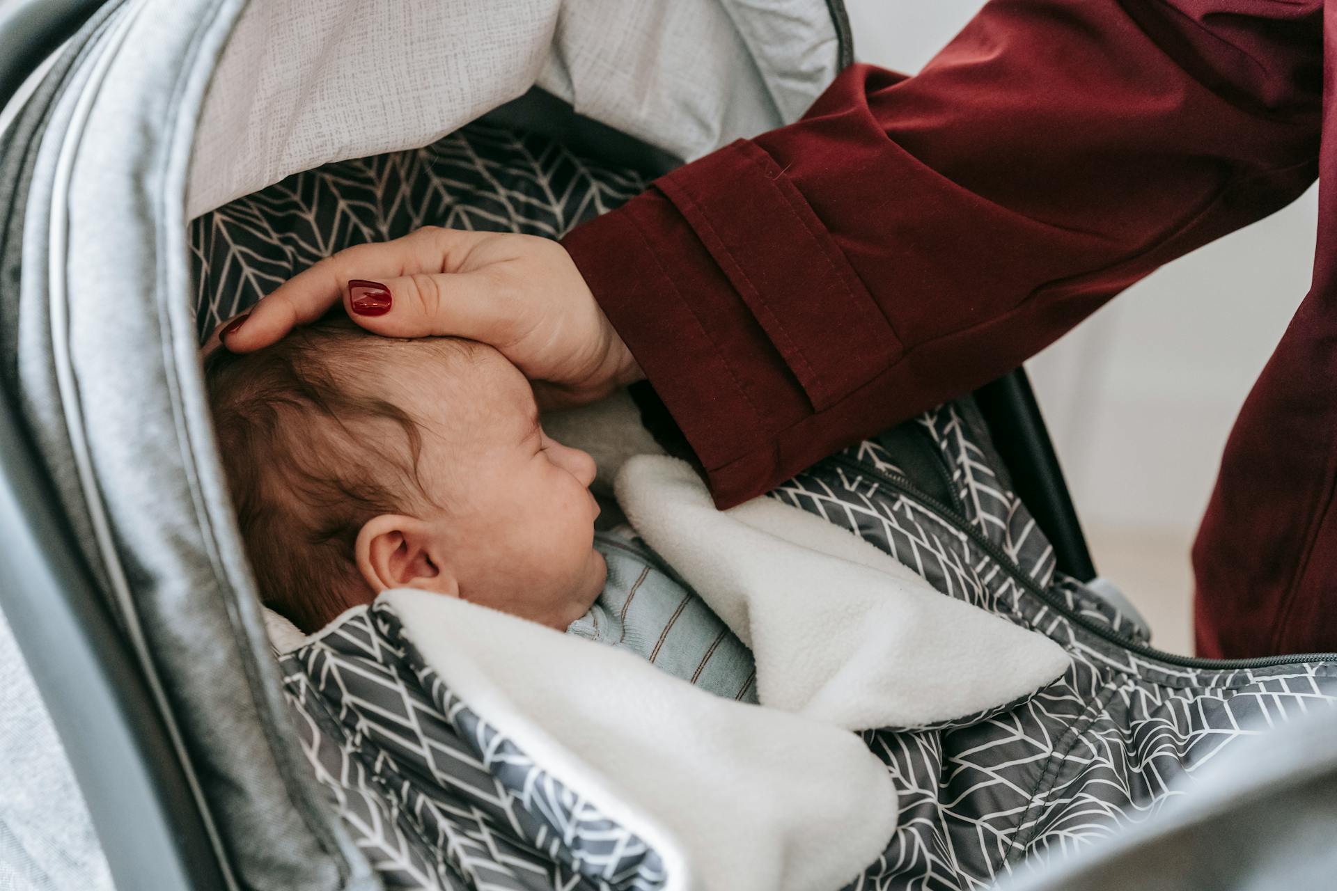 A mother admiring her baby sleeping in the stroller | Source: Pexels