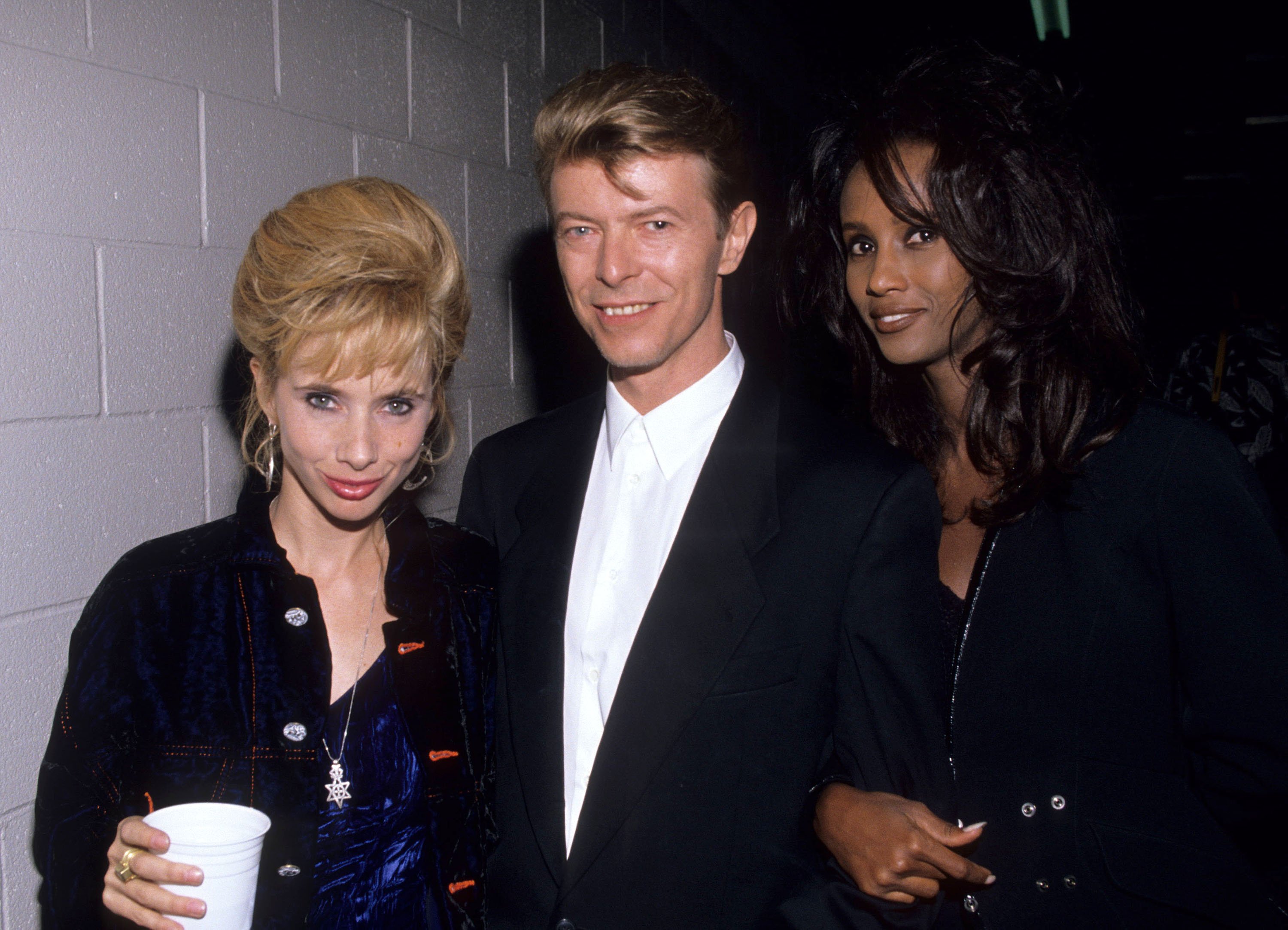 Picture of David Bowie and Iman with a guest at a David Bowie concert, circa 1990 | Source: Getty Images