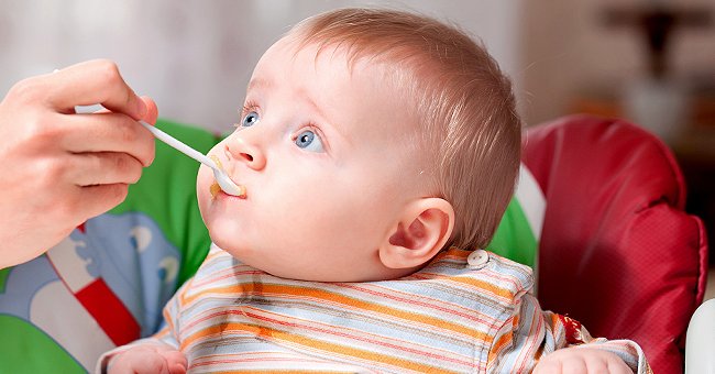 A young child is being fed with a spoon. | Photo: Shutterstock