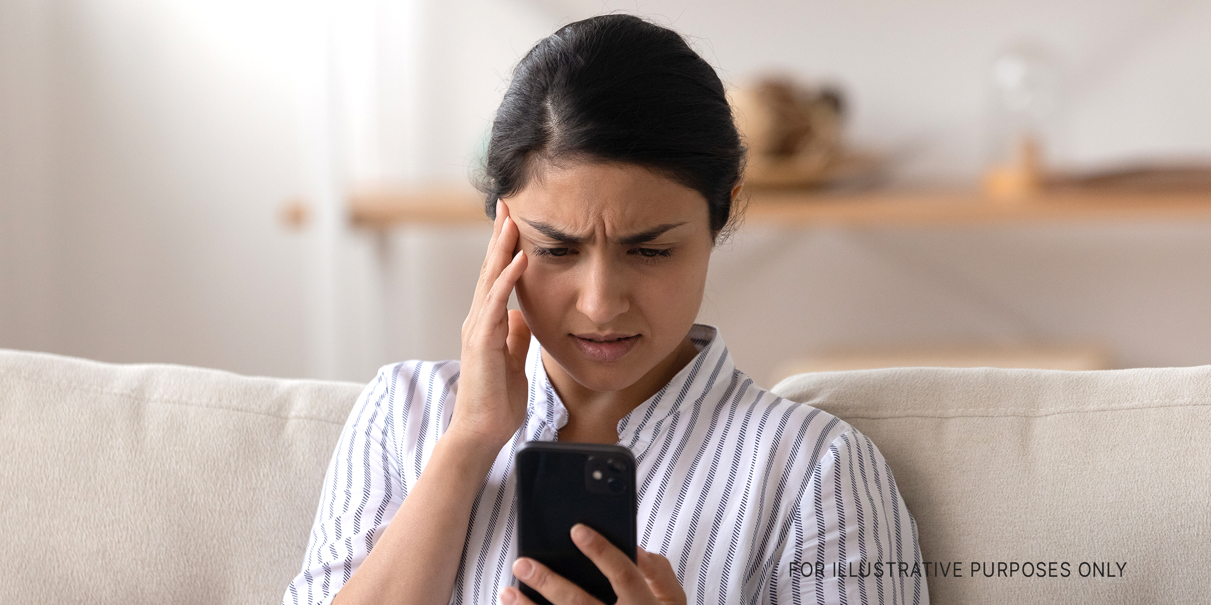Woman looking at her cellphone with a worried expression on her face | Source: Shutterstock