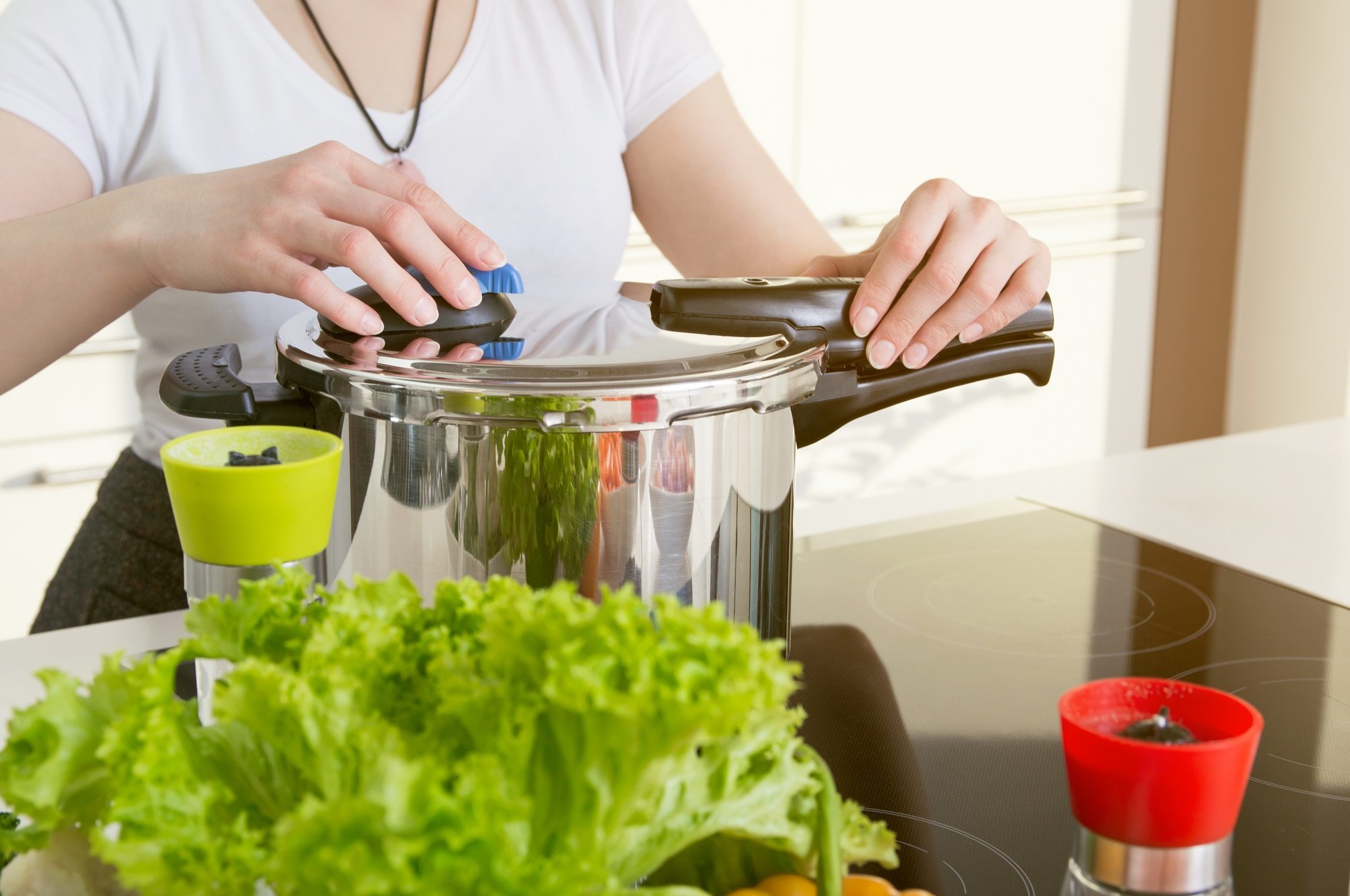 Mujer prepara comida usando olla a presión. | Foto: Shutterstock    