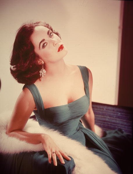 Portrait of British-born actor Elizabeth Taylor in a form-fitting green dress | Photo Credit: Getty Images