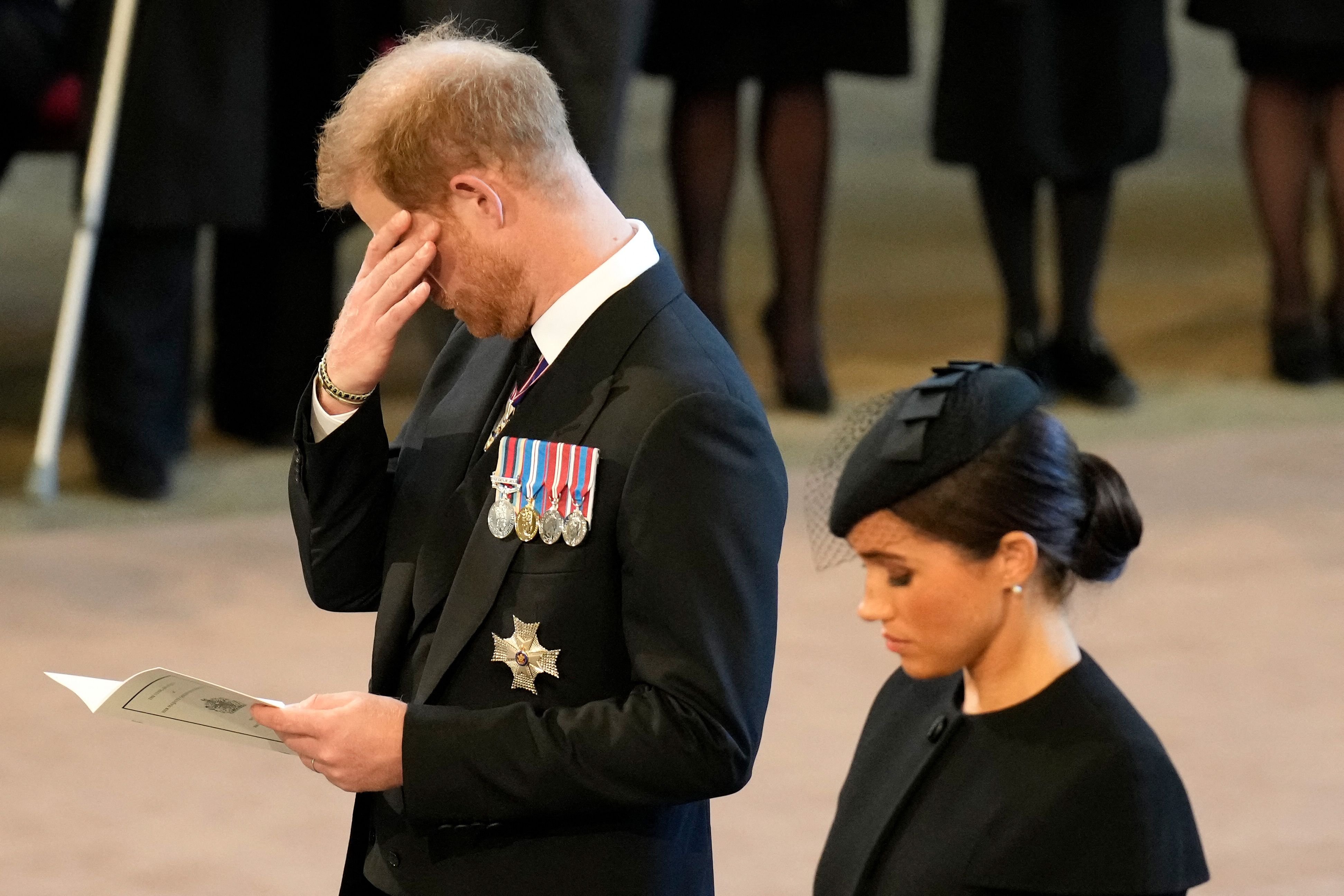 El príncipe Harry se limpia una lágrima mientras presenta sus respetos dentro de Westminster Hall en el Palacio de Westminster, donde el ataúd de la reina Elizabeth II reposará en un catafalco, en Londres el 14 de septiembre de 2022 | Foto: Getty Images