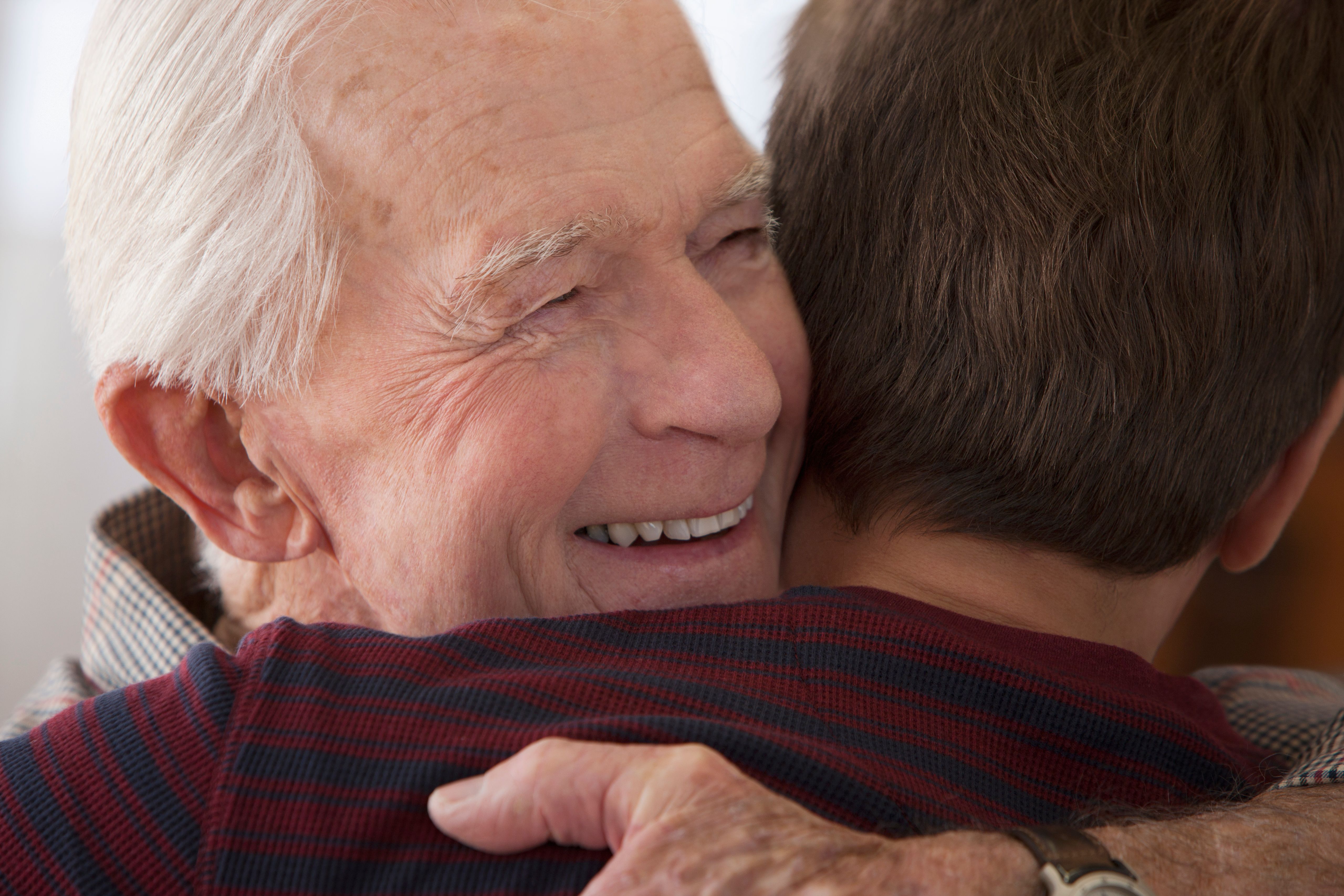 An elderly man hugging a boy. | Source: Shutterstock