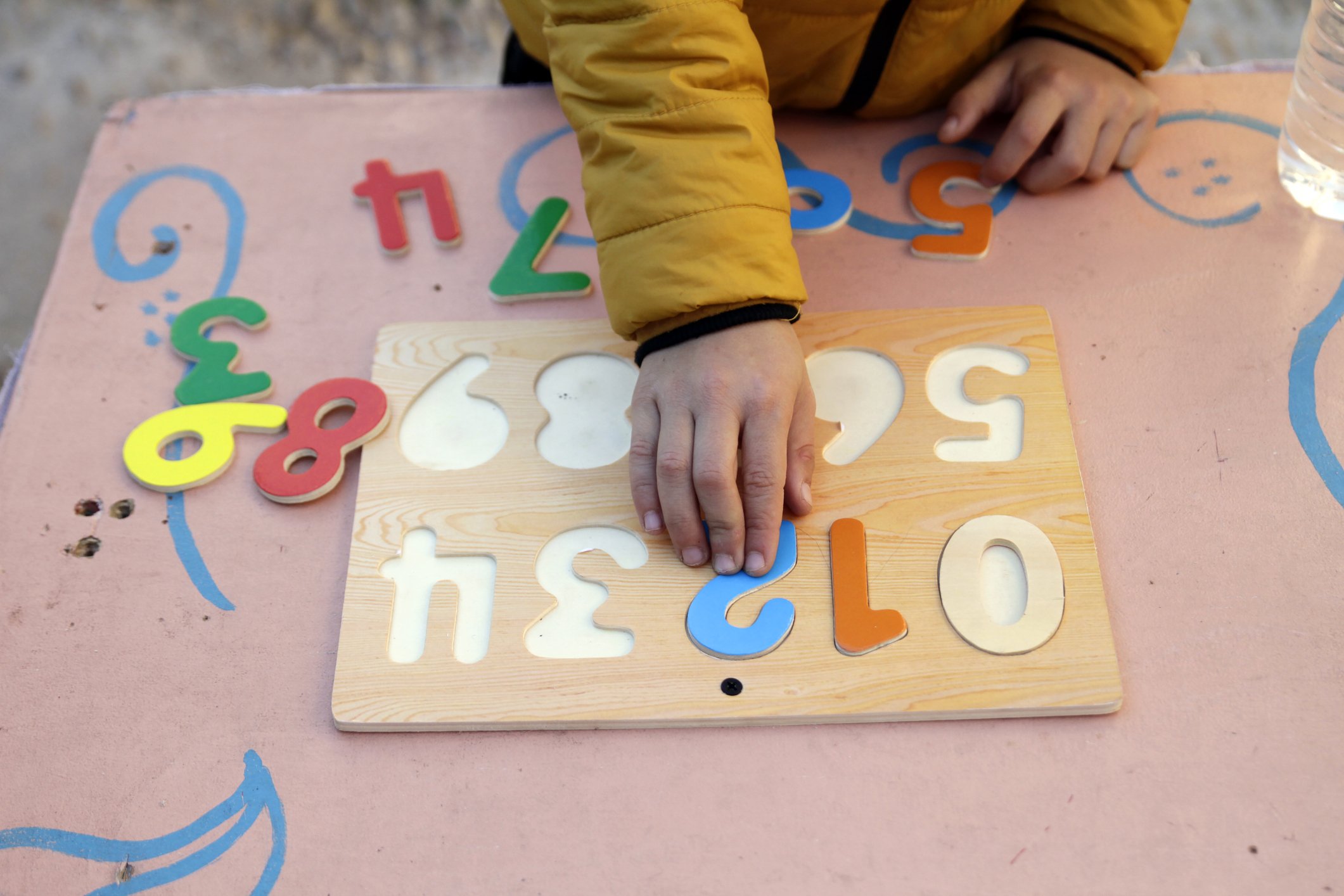 Junge spielt mit hölzernen Zahlen Puzzle I Quelle: Getty Images