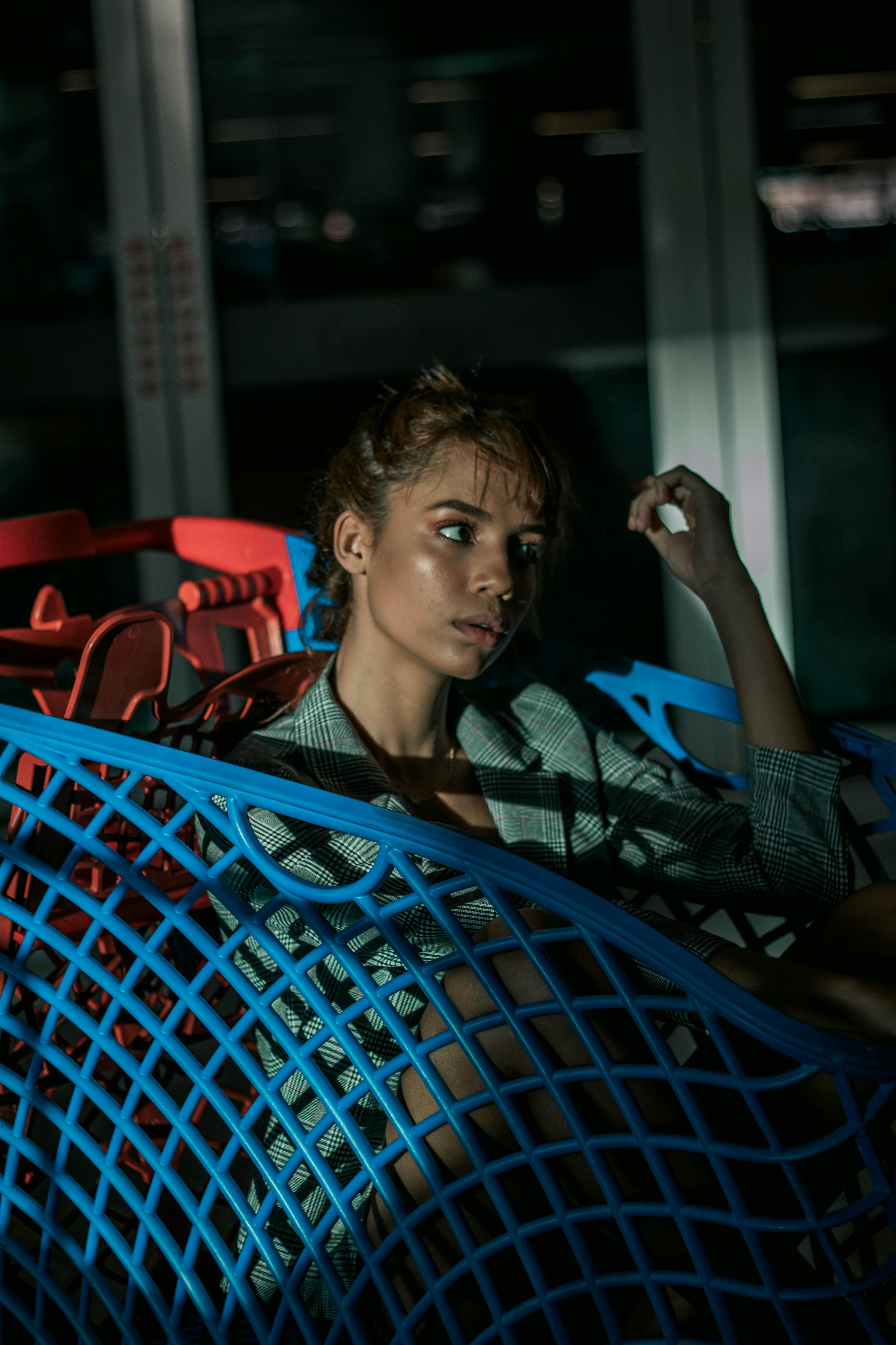 A young woman in deep thoughts sitting in aa supermarket cart. | Source: Pexels
