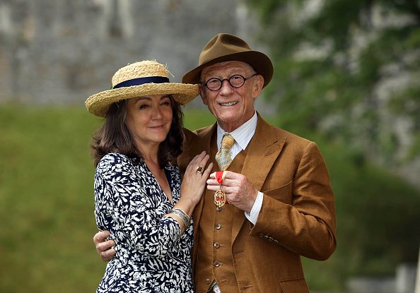 Der britische Schauspieler Sir John Hurt posiert mit seiner Frau Anwen nach der Verleihung des Ritterschlags durch Königin Elizabeth II. während einer Investiturzeremonie auf Schloss Windsor am 17. Juli 2015 in London | Quelle: Getty Images