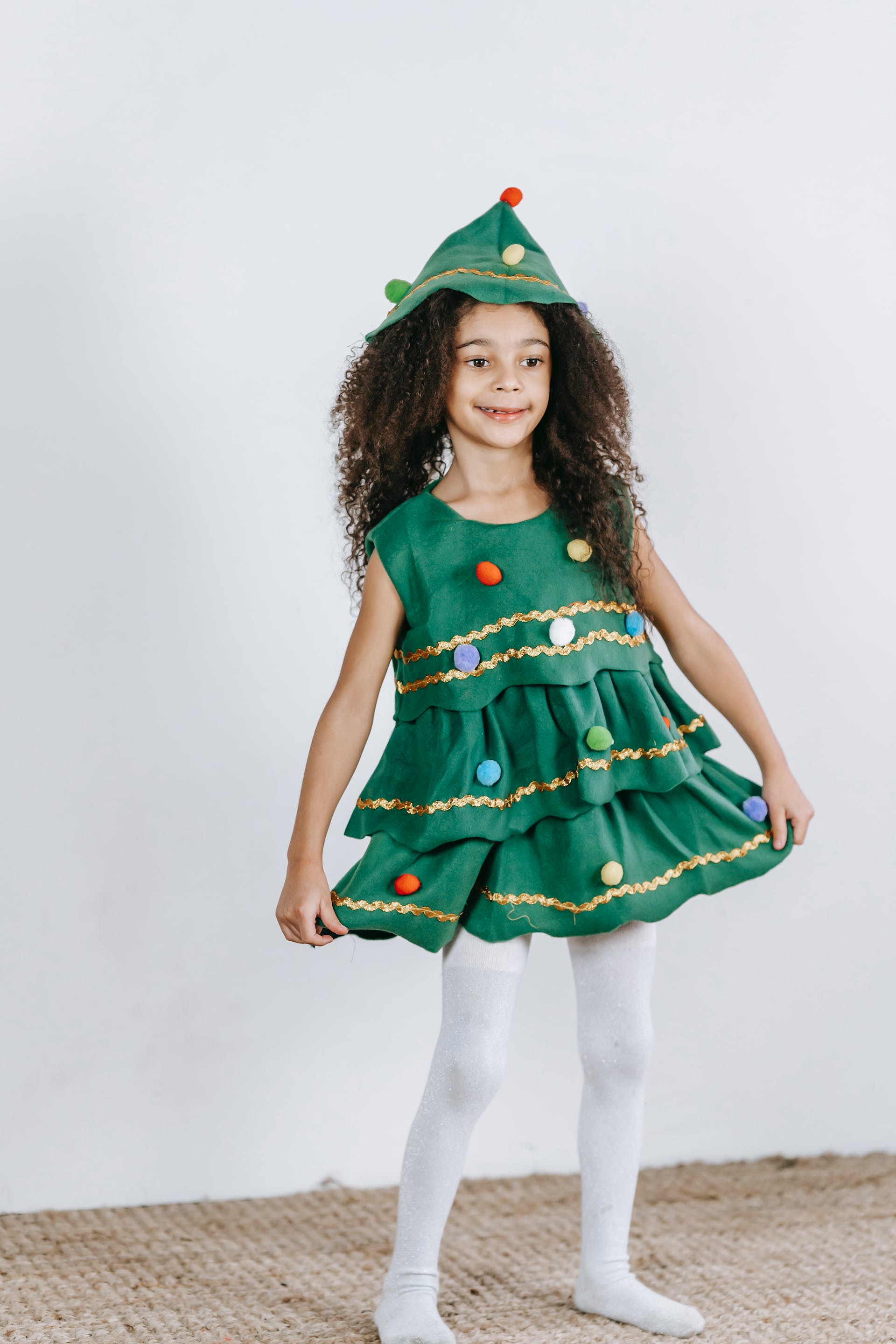 A little girl wearing a Christmas tree costume | Source: Pexels