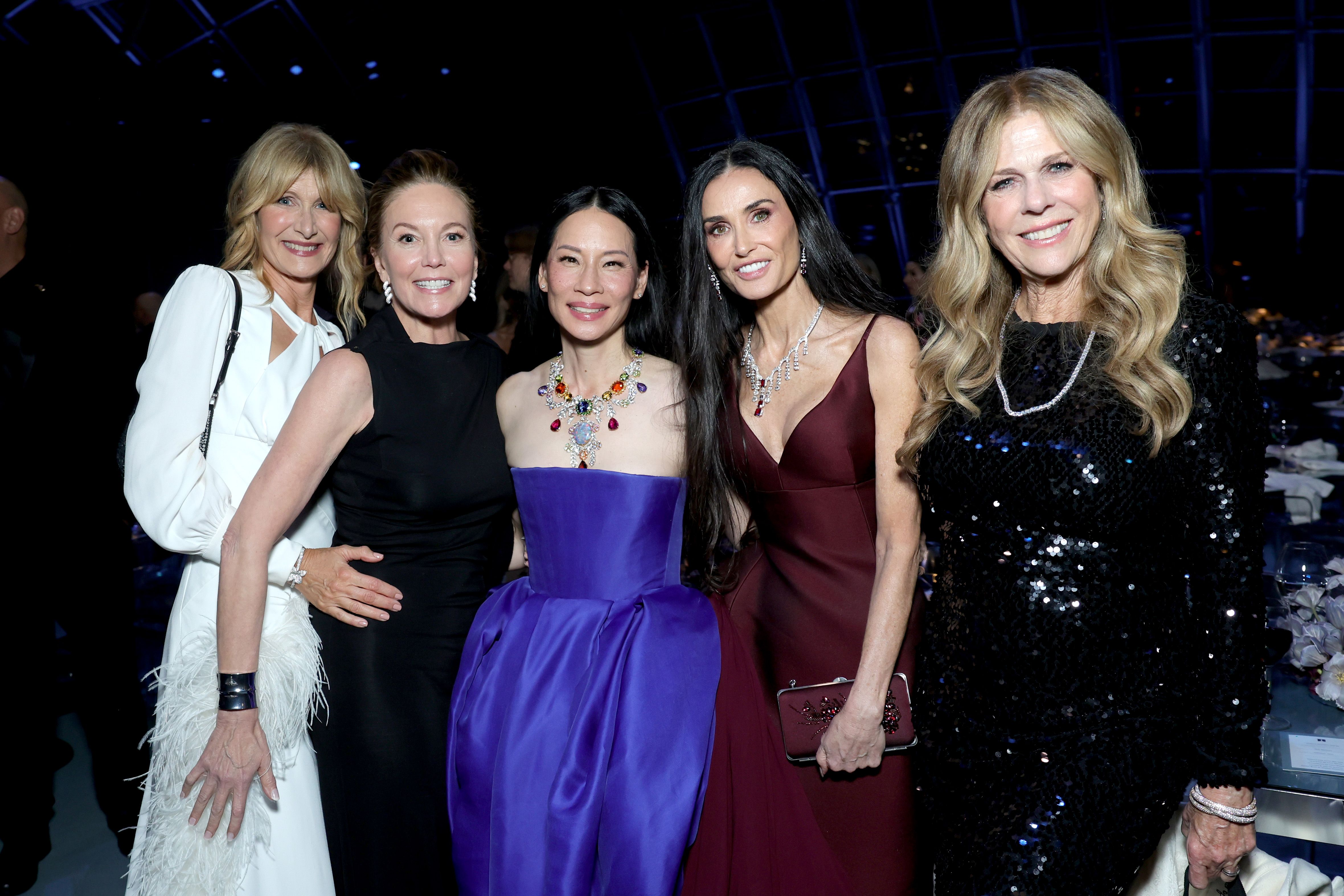 Demi Moore joins Laura Dern, Diane Lane, Lucy Liu, and Rita Wilson for a powerhouse group photo, standing tall in deep maroon as the women pose with ease and elegance at the glamorous Academy Museum Gala.