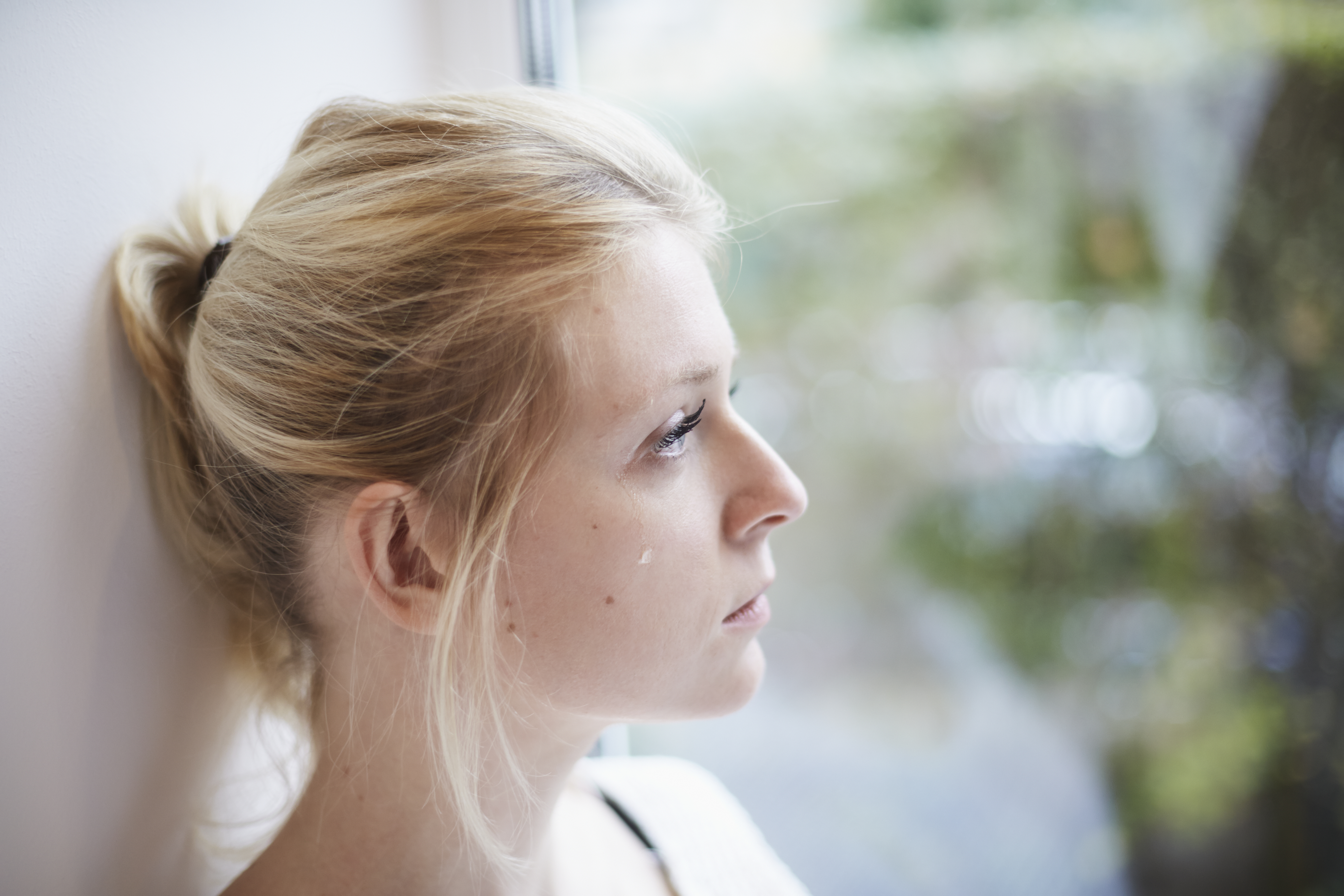 Young woman crying at the window | Source: Getty Images