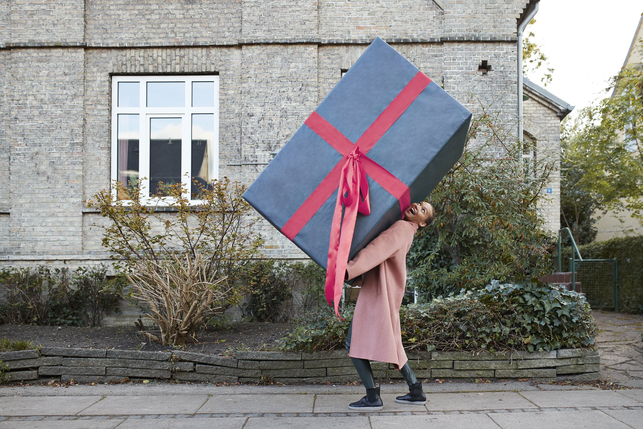 Glückliche Frau, die große Geschenkbox trägt I Quelle: Getty Images