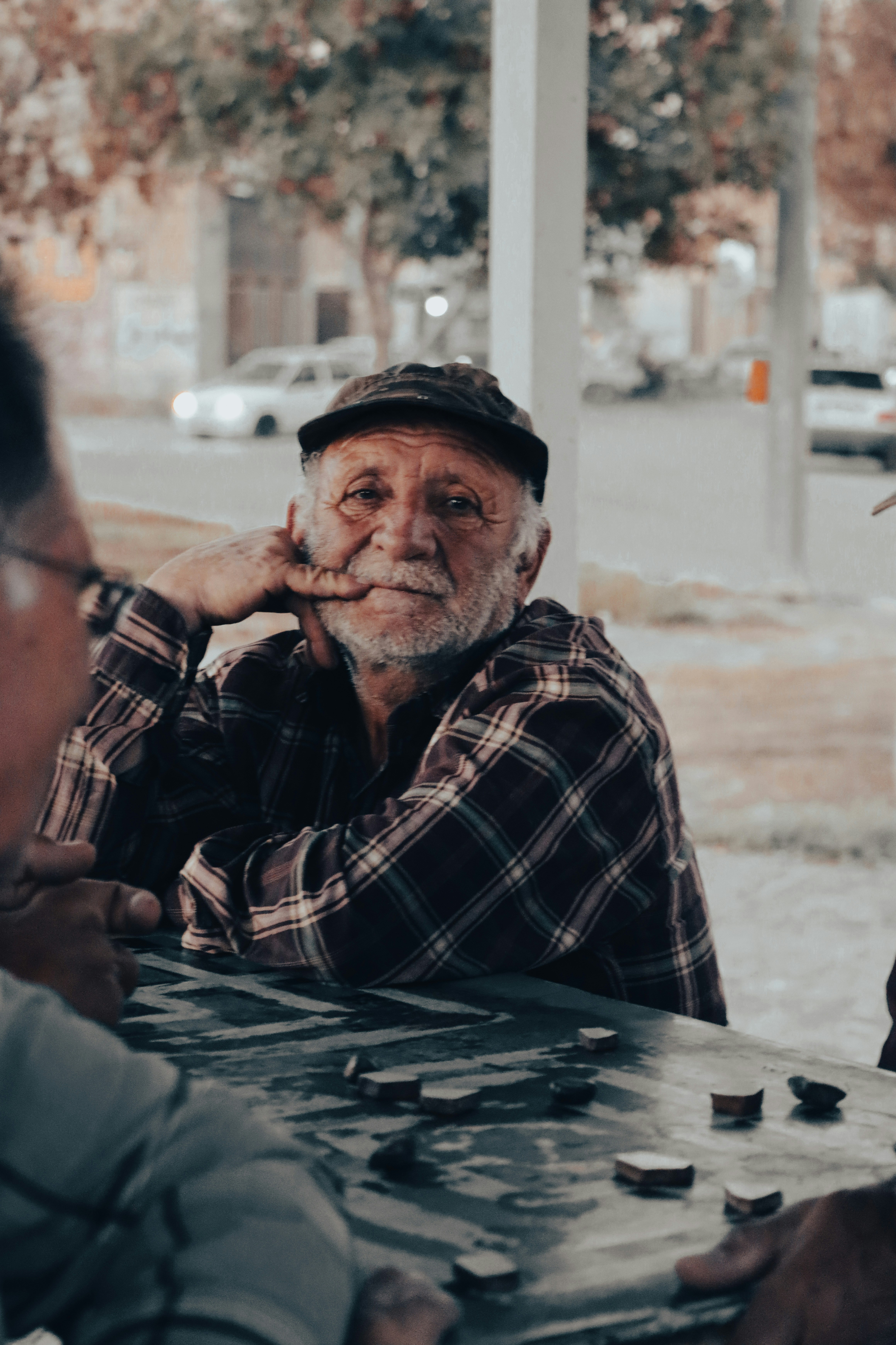 Elderly man sitting at a table | Source: Unsplash