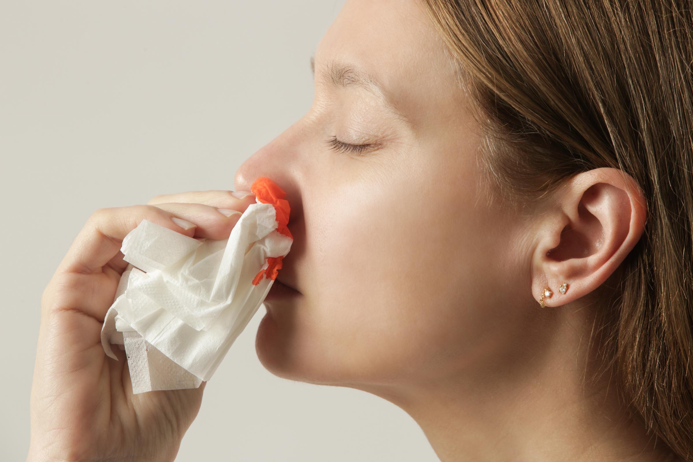 A young woman wiping blood off her nose | Source: Getty Images