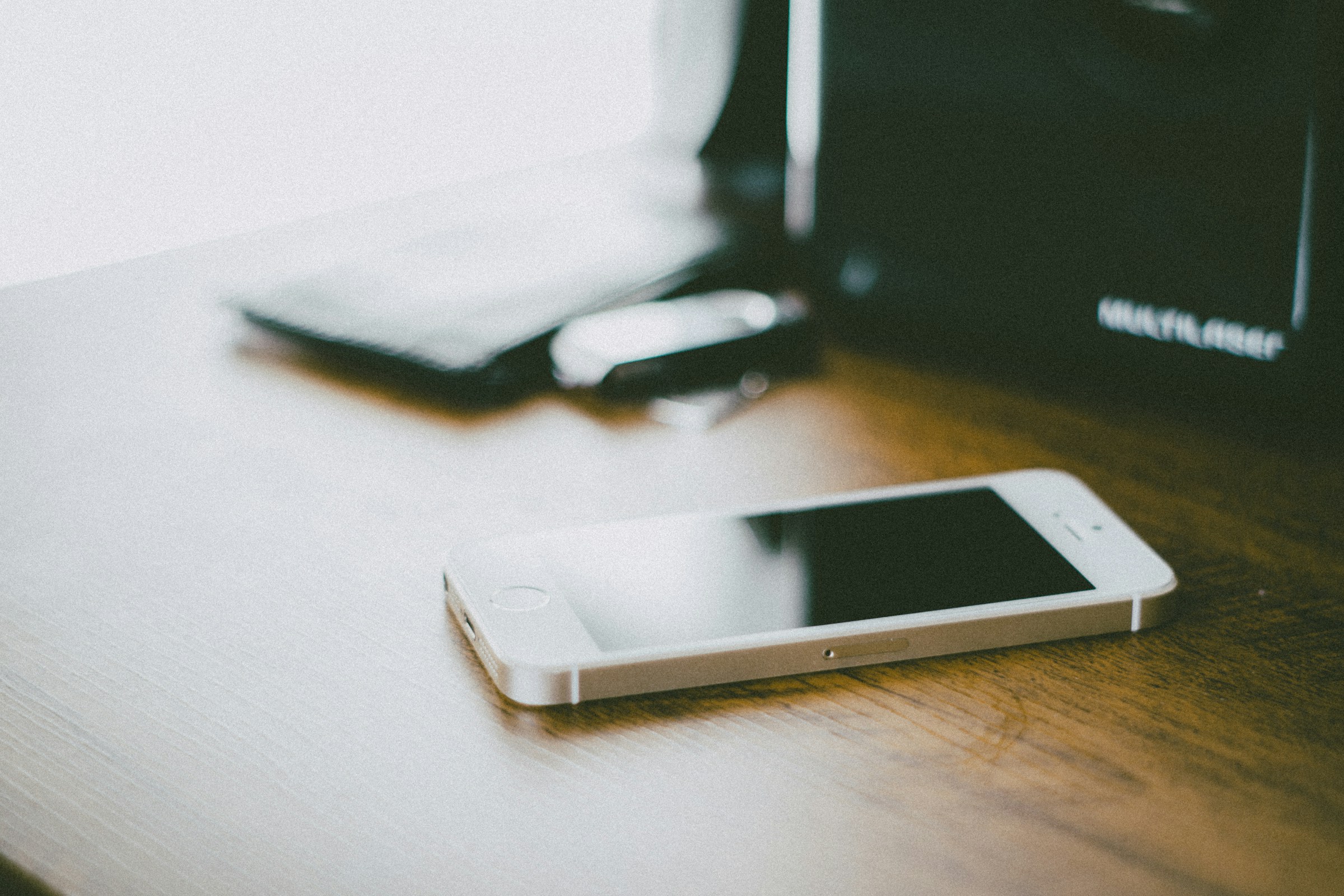 A smartphone on a brown wooden table | Source: Unsplash