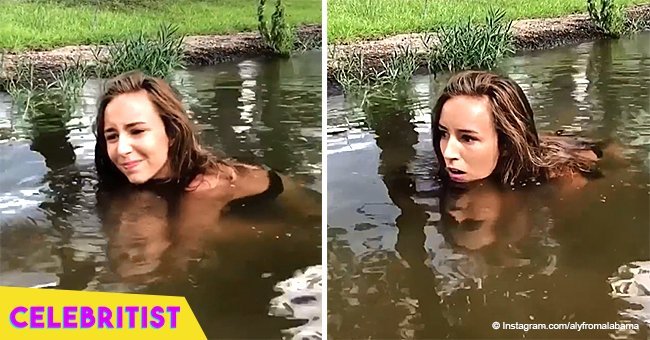 Girl squats in muddy water, puts her hands to the bottom and pulls out a huge creature