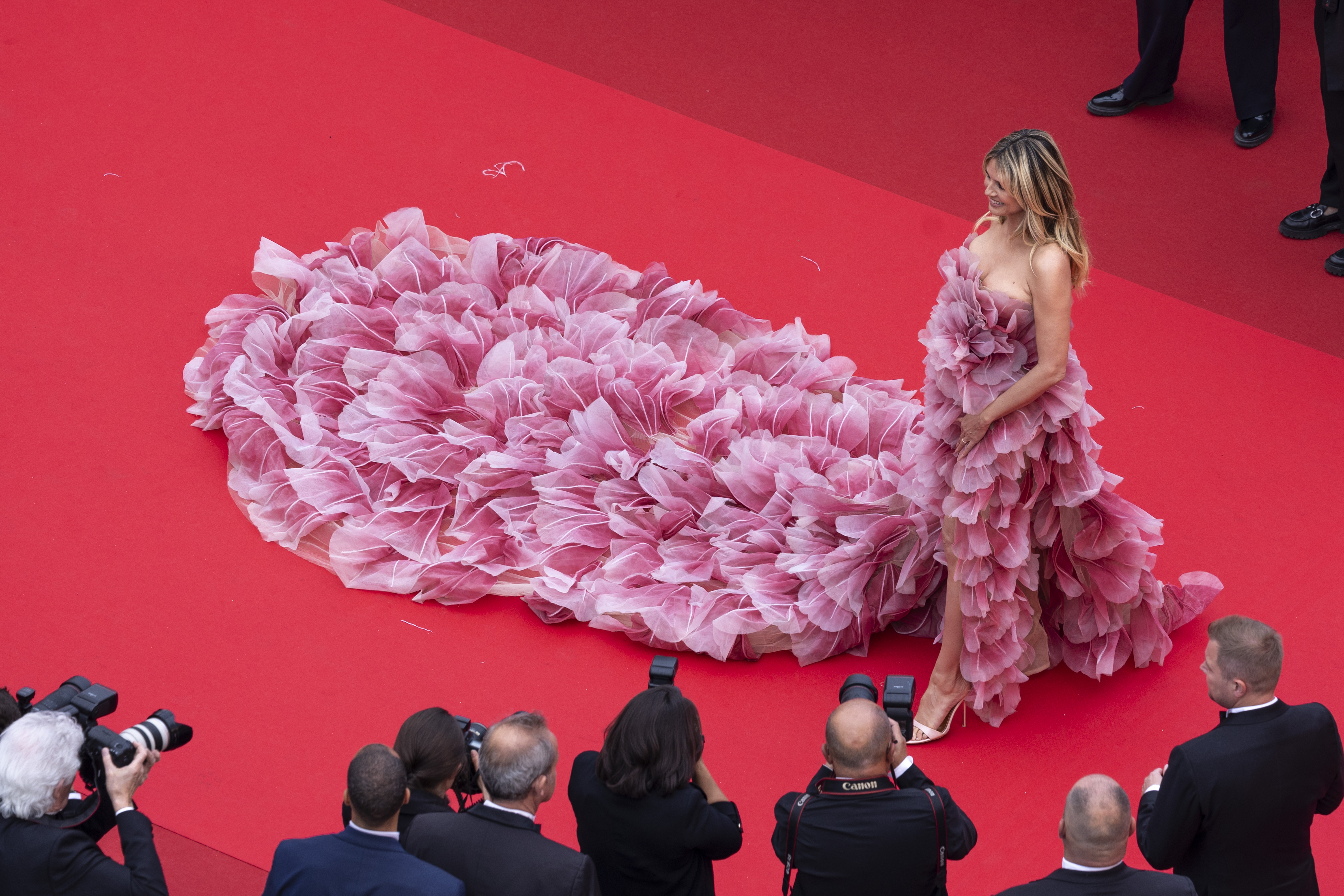 An aerial shot offers a striking view of Klum’s gown from above, subtly revealing her cleavage as part of the intricate neckline.