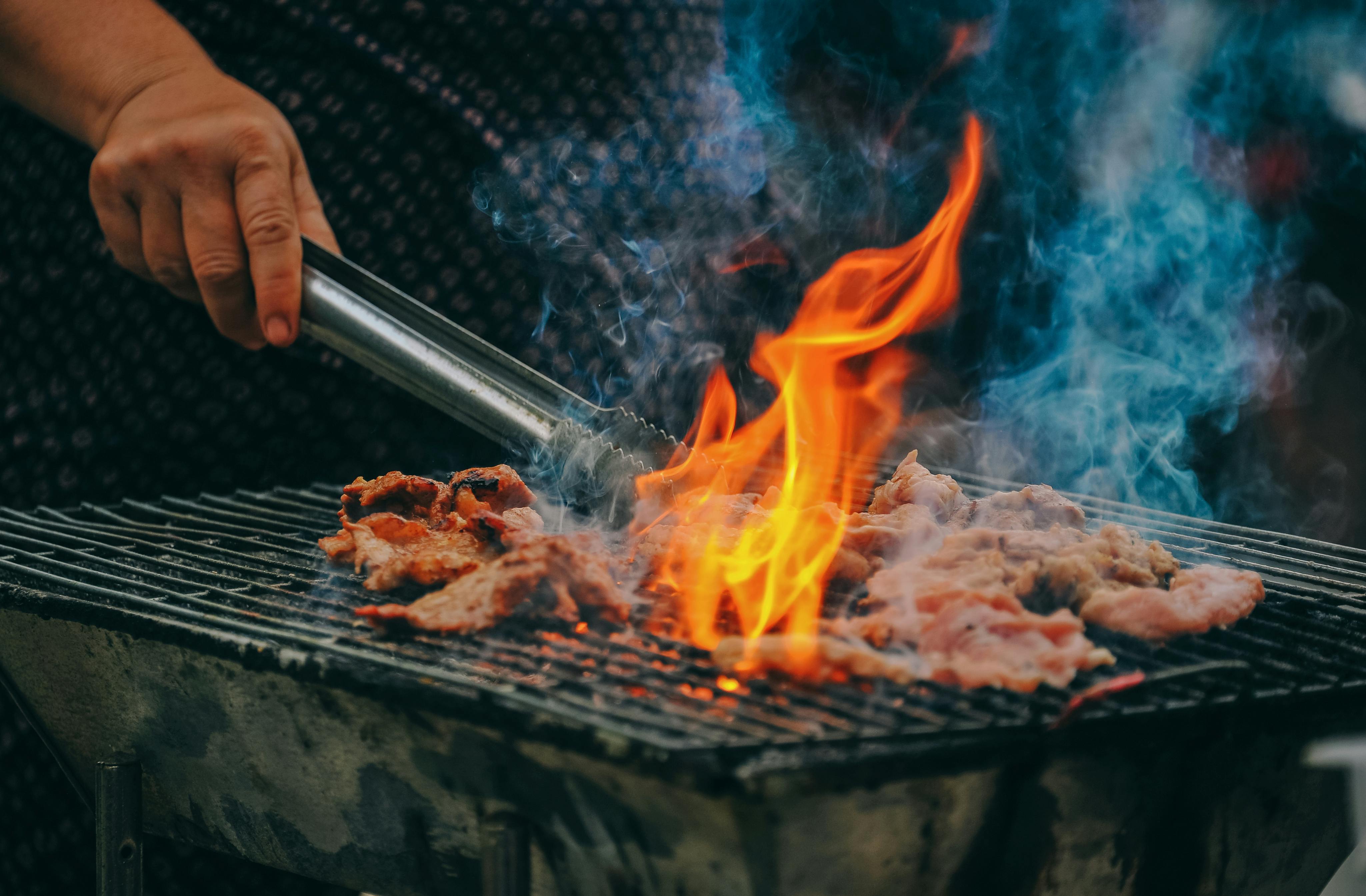 A close-up of a man cooking meat | Source: Pexels