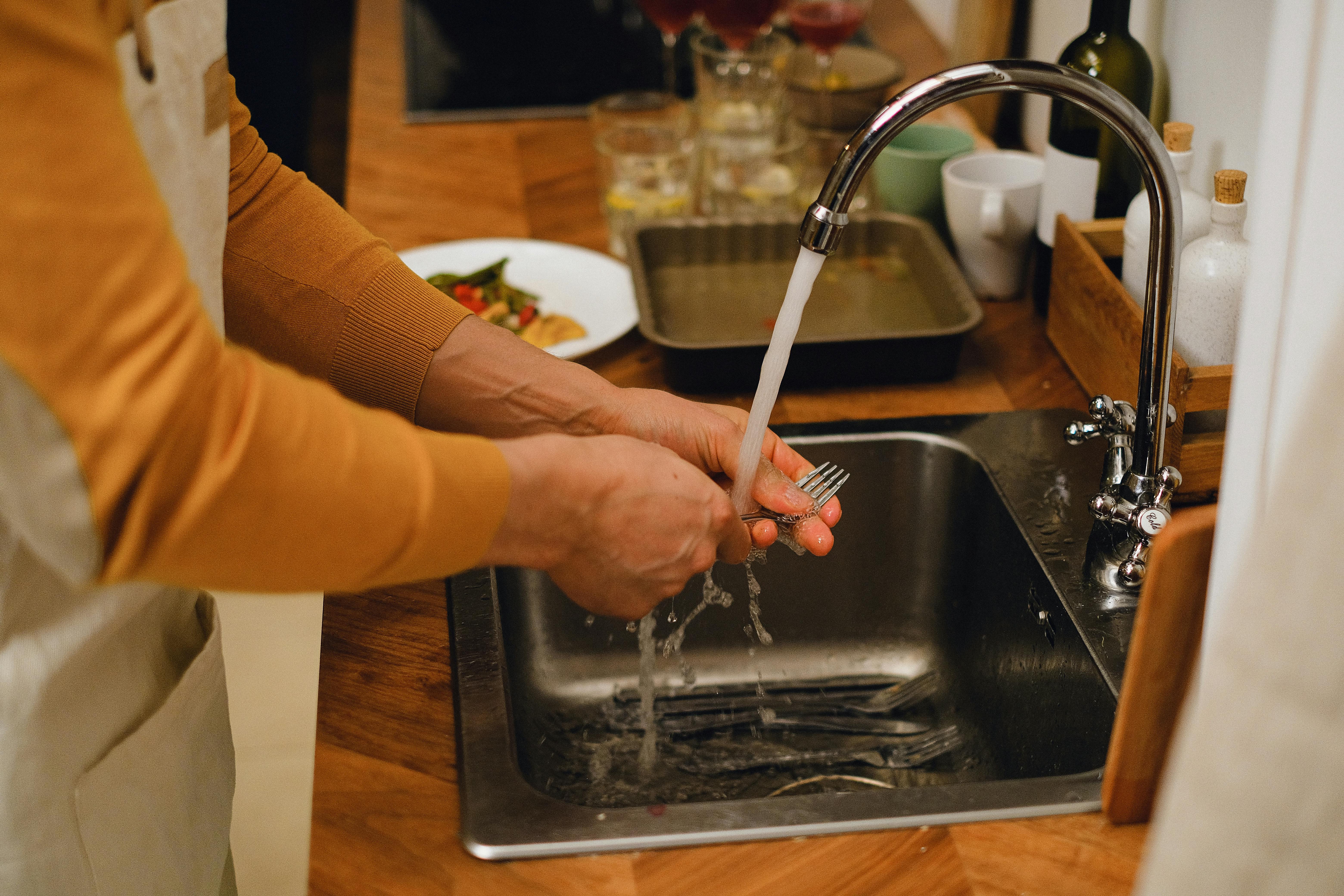 A woman rinsing her fork | Source: Pexels