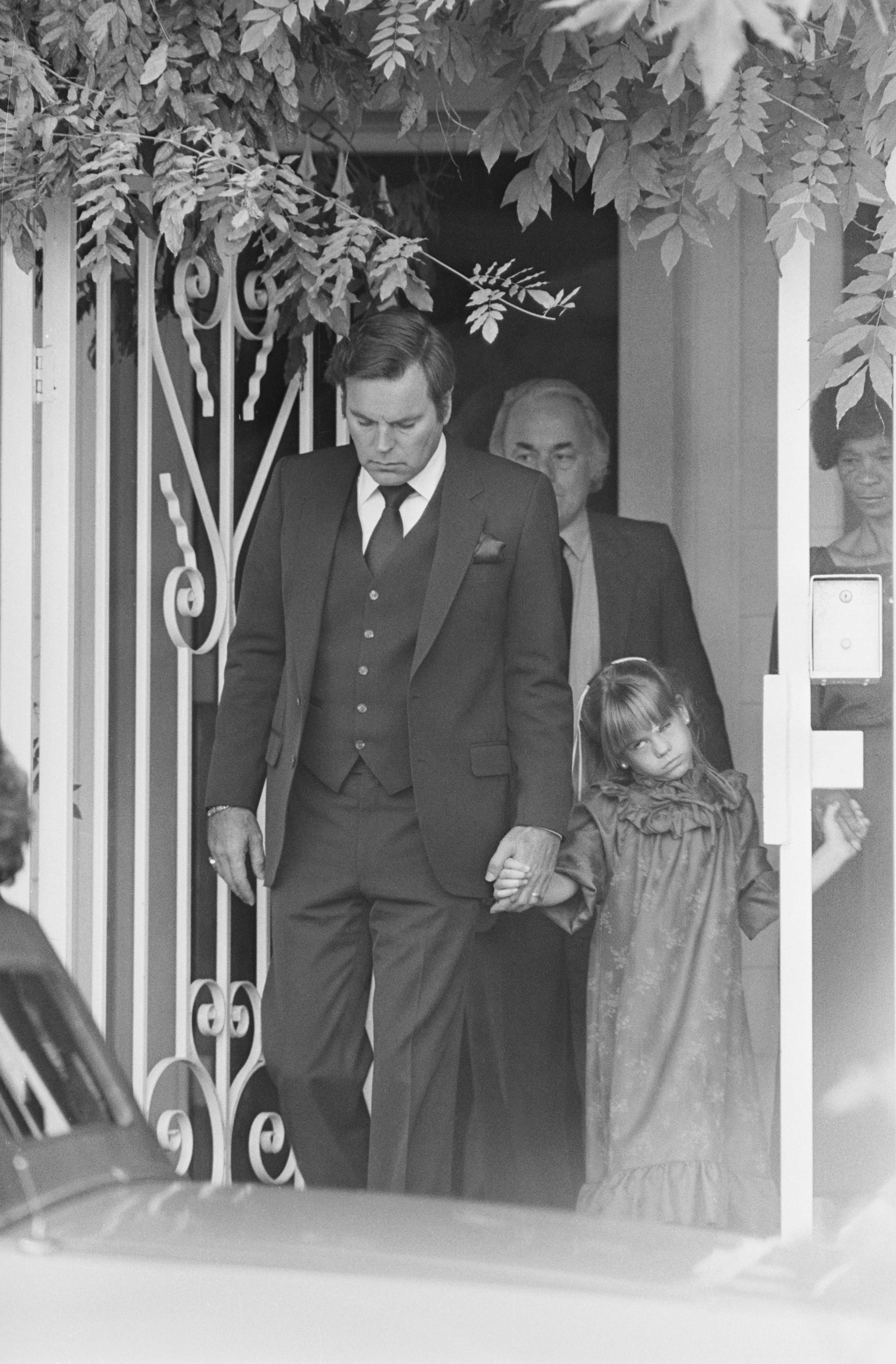 Actor Robert Wagner leading his daughter, Courtney, age 6, as they left their Beverly Hills home on the way to the funeral services for Natalie Wood | Source: Getty Images