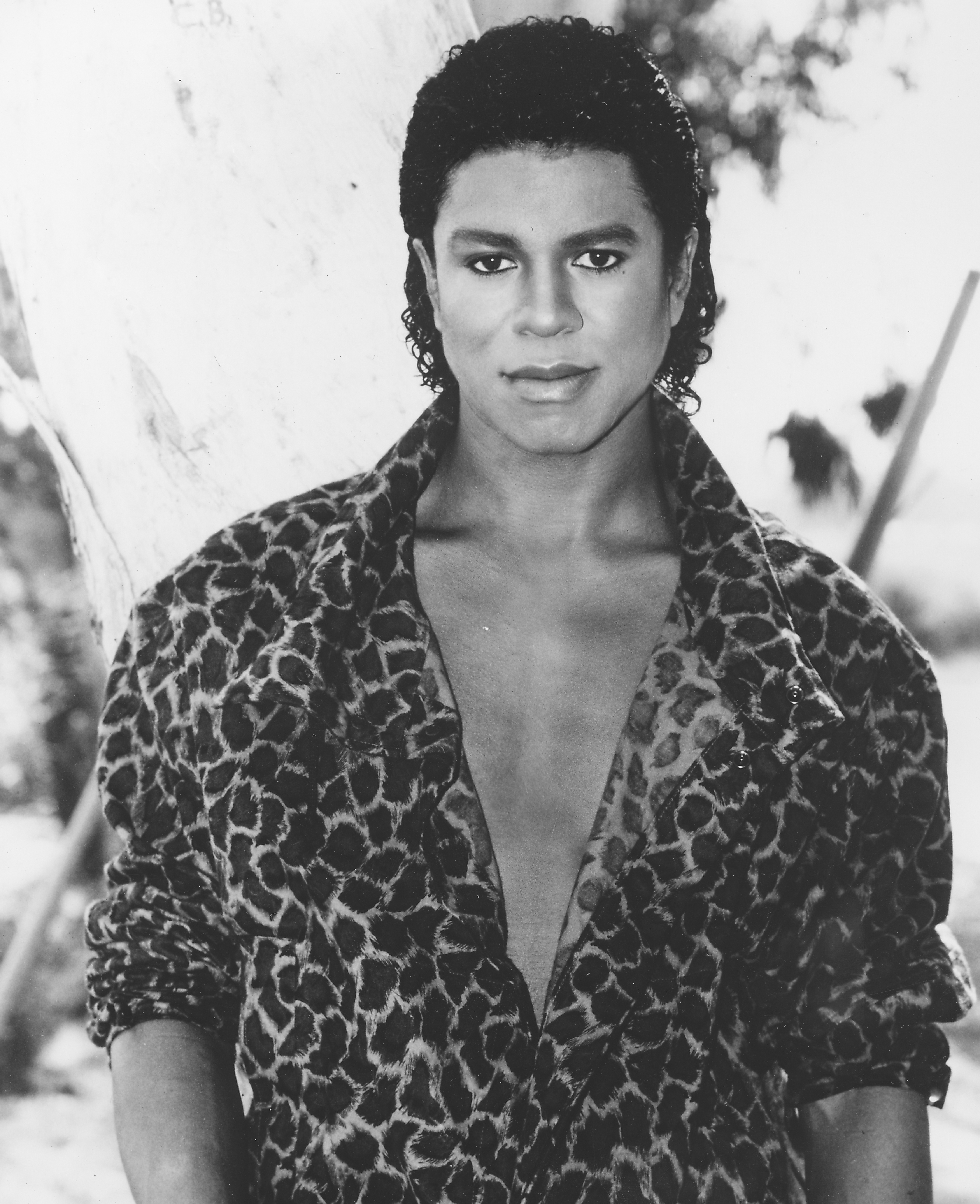 Jermaine Jackson poses in a striking patterned jacket with an open collar, projecting a confident, effortless cool. His steady gaze and relaxed styling capture a polished yet understated era portrait look.