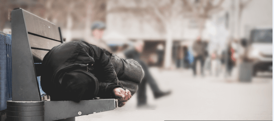 Un sans abris qui dort sur une banquette | Source : Shutterstock Un sans abris qui dort sur une banquette | Source : Shutterstock
