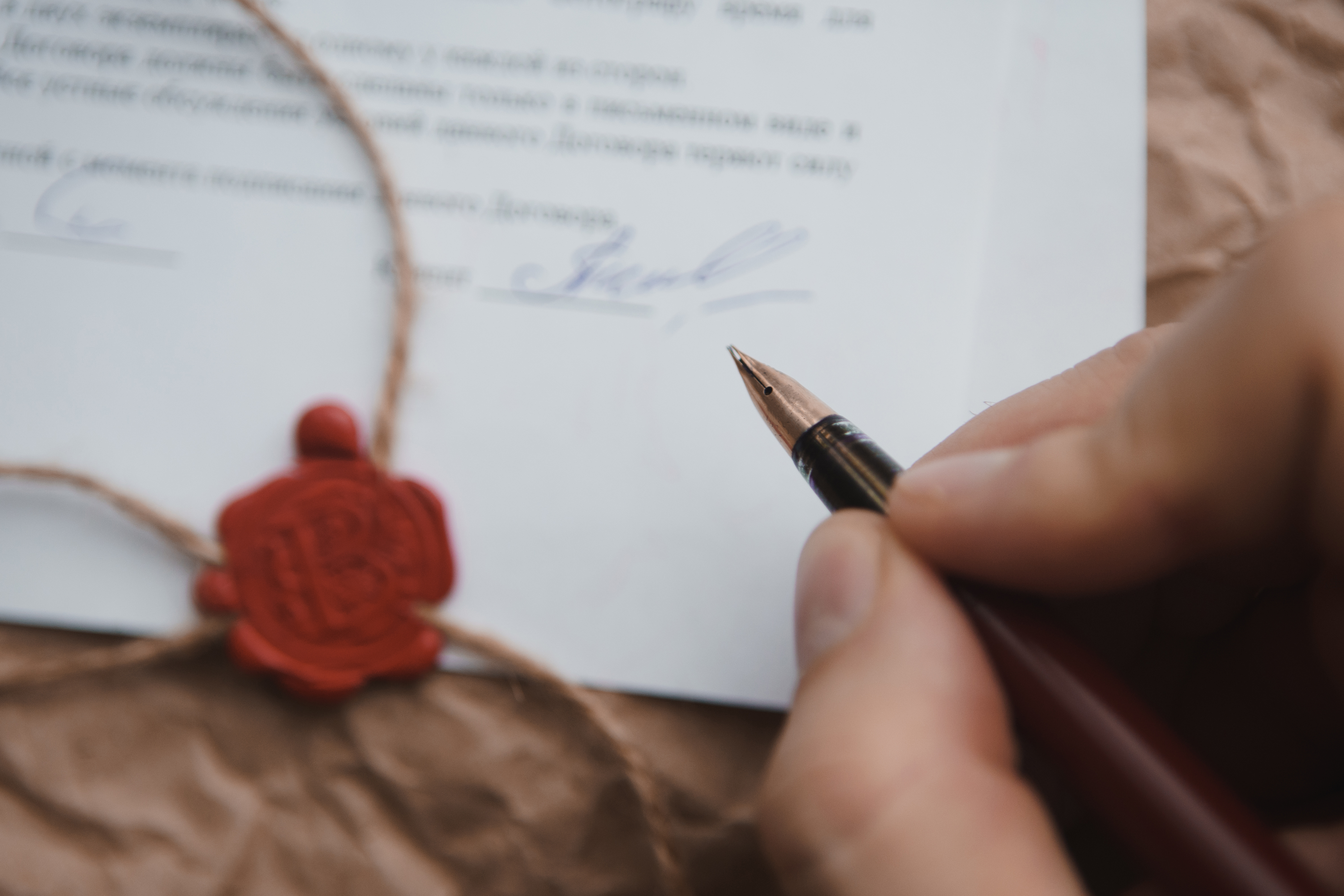 A hand signing a last will and testament | Source: Shutterstock