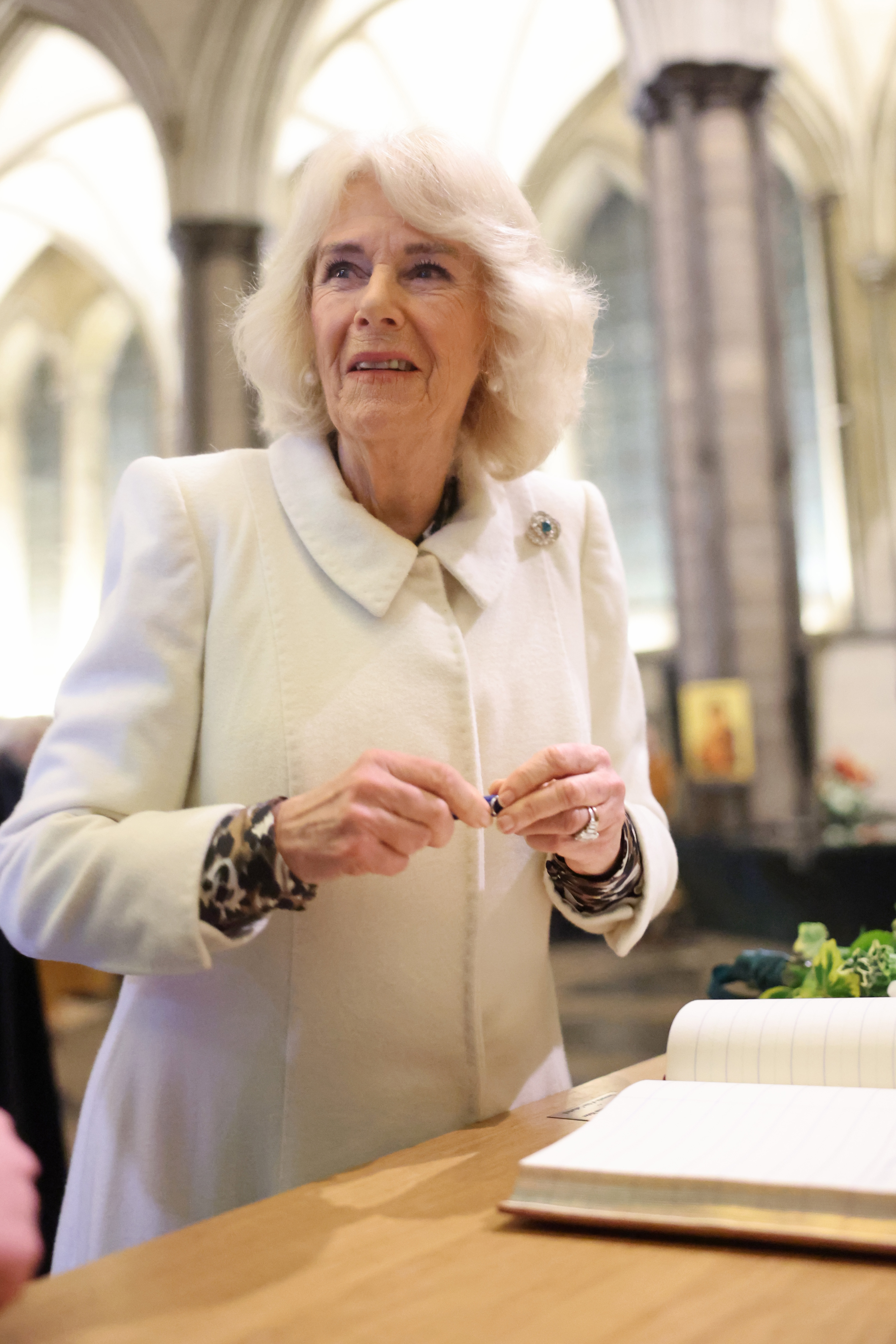Queen Camilla signs the guestbook during a musical evening at Salisbury Cathedral on February 8, 2024 in Salisbury, England | Source: Getty Images