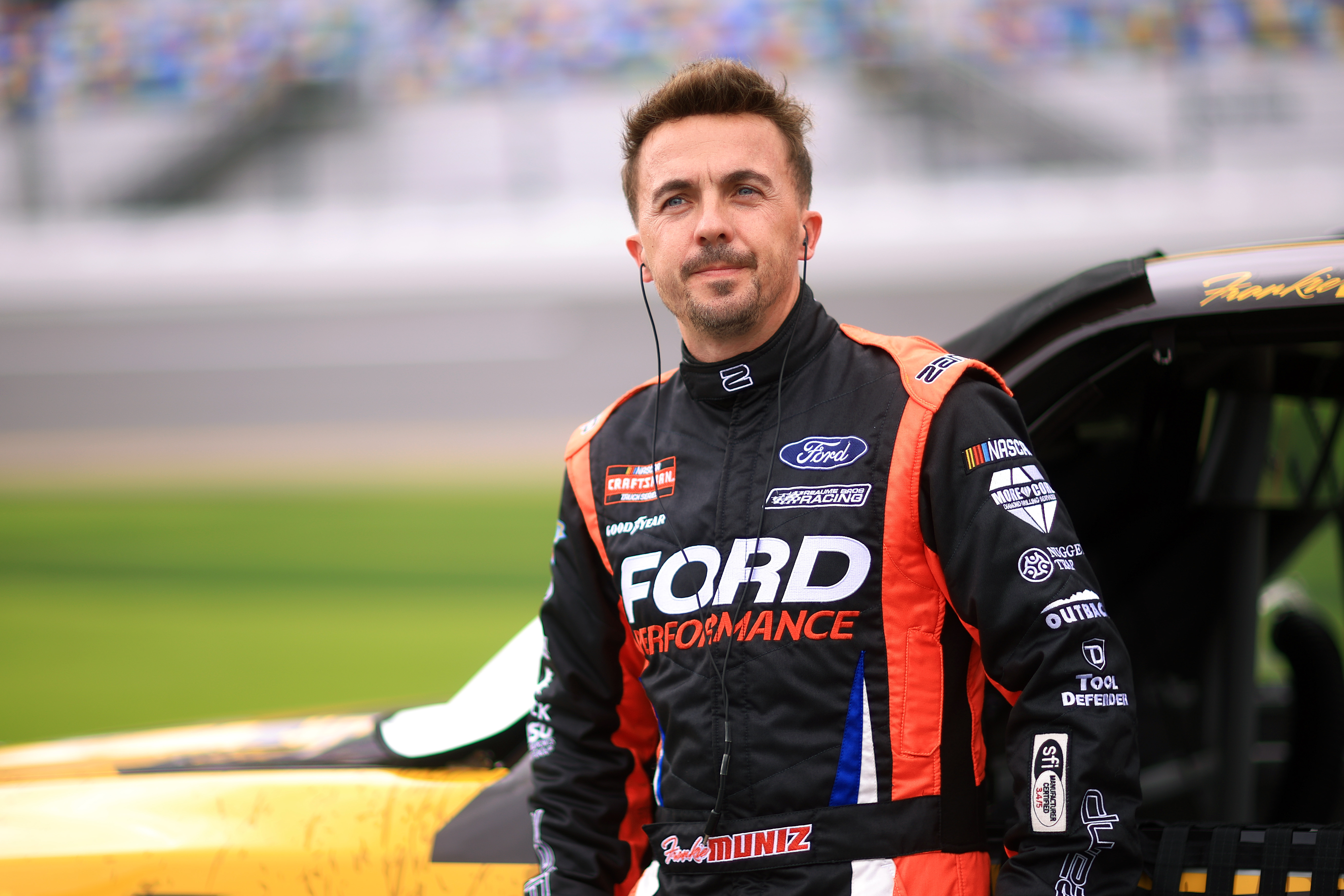 By 2025, Muniz had swapped soundstages for speedways. Suited up in a full racing jumpsuit branded with “Ford Performance,” he posed beside his stock car with a focused expression and earbuds in. Now a professional race car driver, Muniz has embraced a drastically different path outside of Hollywood.