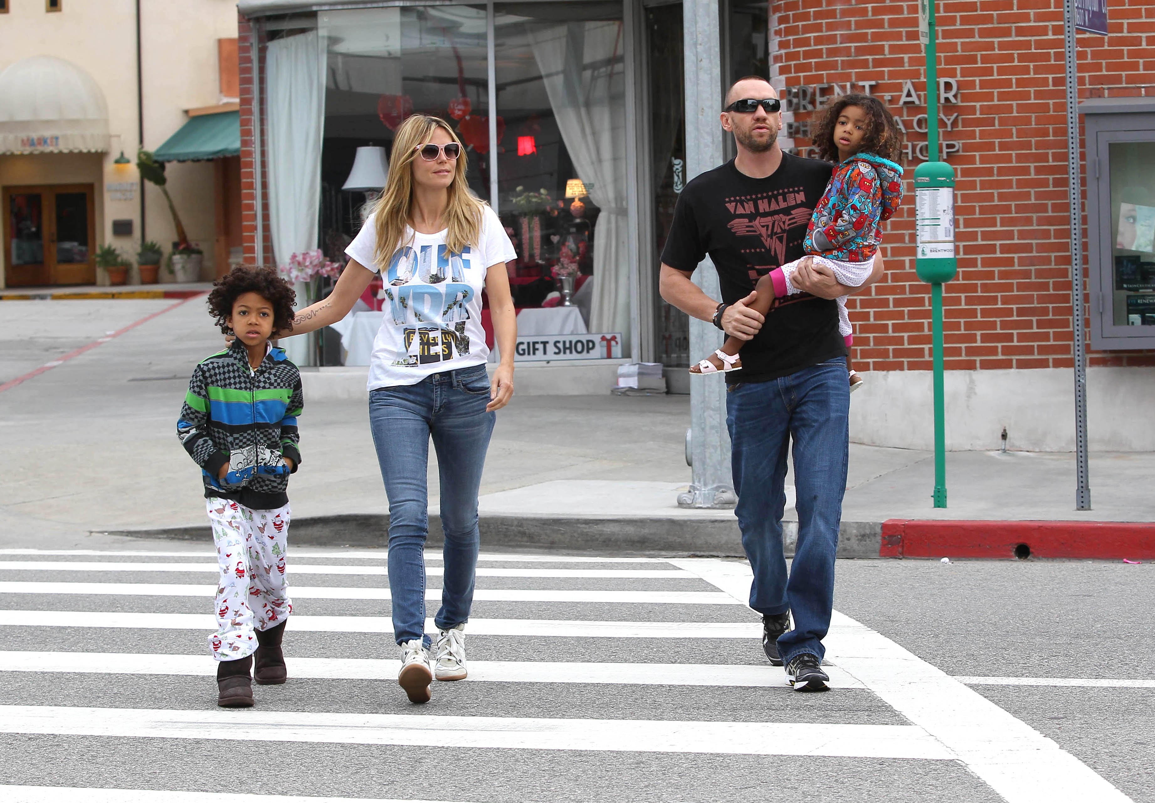 Stepping confidently across a quiet street in Los Angeles, Heidi Klum leads the way with Henry Samuel at her side, while Martin Kirsten carries little Lou.