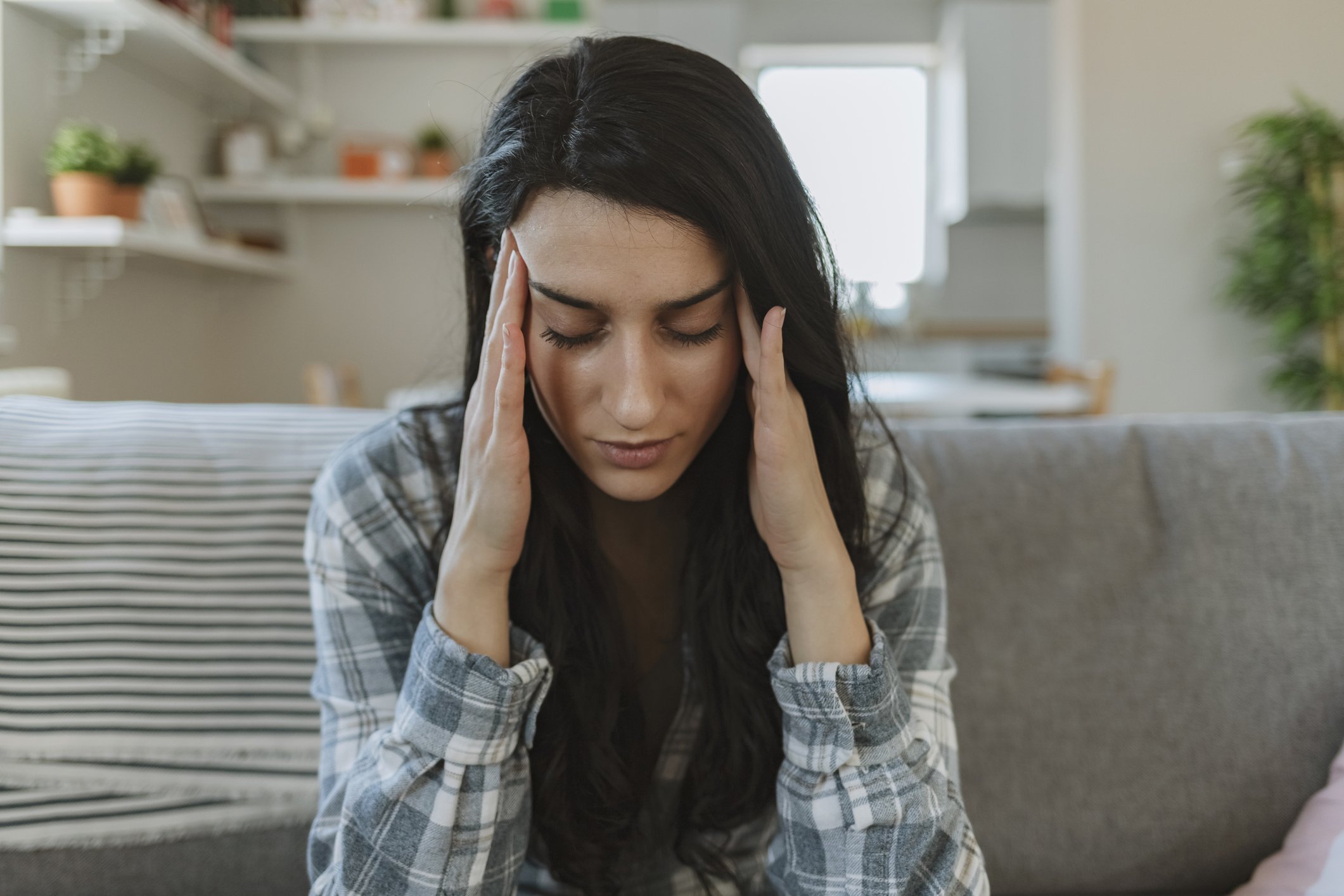 Frau berührt ihren Kopf und leidet unter Kopfschmerzen I Quelle: Getty Images