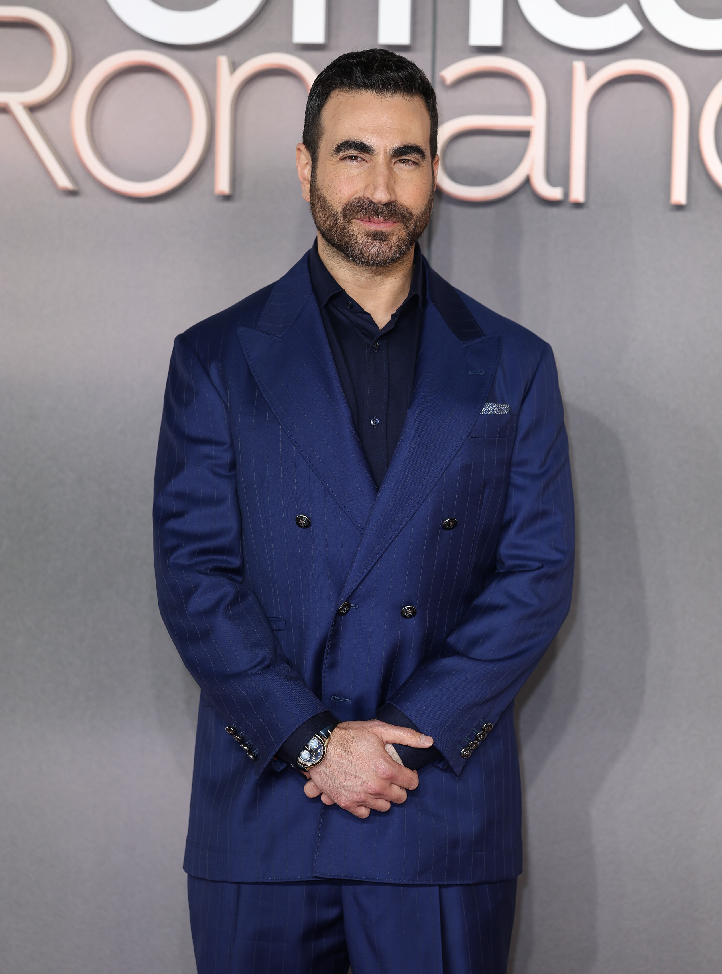 Brett Goldstein attends the world premiere of "The Romance" in a tailored blue suit, the "Ted Lasso" star later paying tribute to Anthony Head. | Source: Getty Images