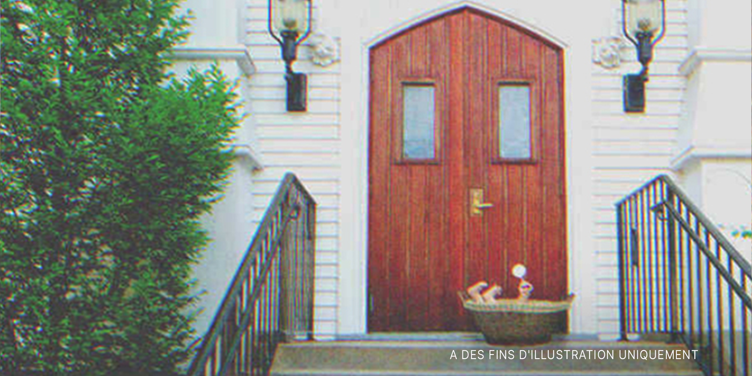 Un bébé dans un panier posé devant une porte | Source : Shutterstock