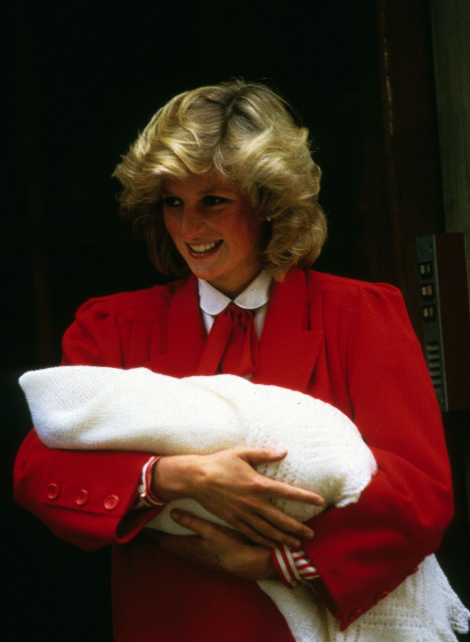 Princess Diana, Princess of Wales, smiles as she carries her newborn baby, Prince Harry when she leaves St. Mary's Hospital