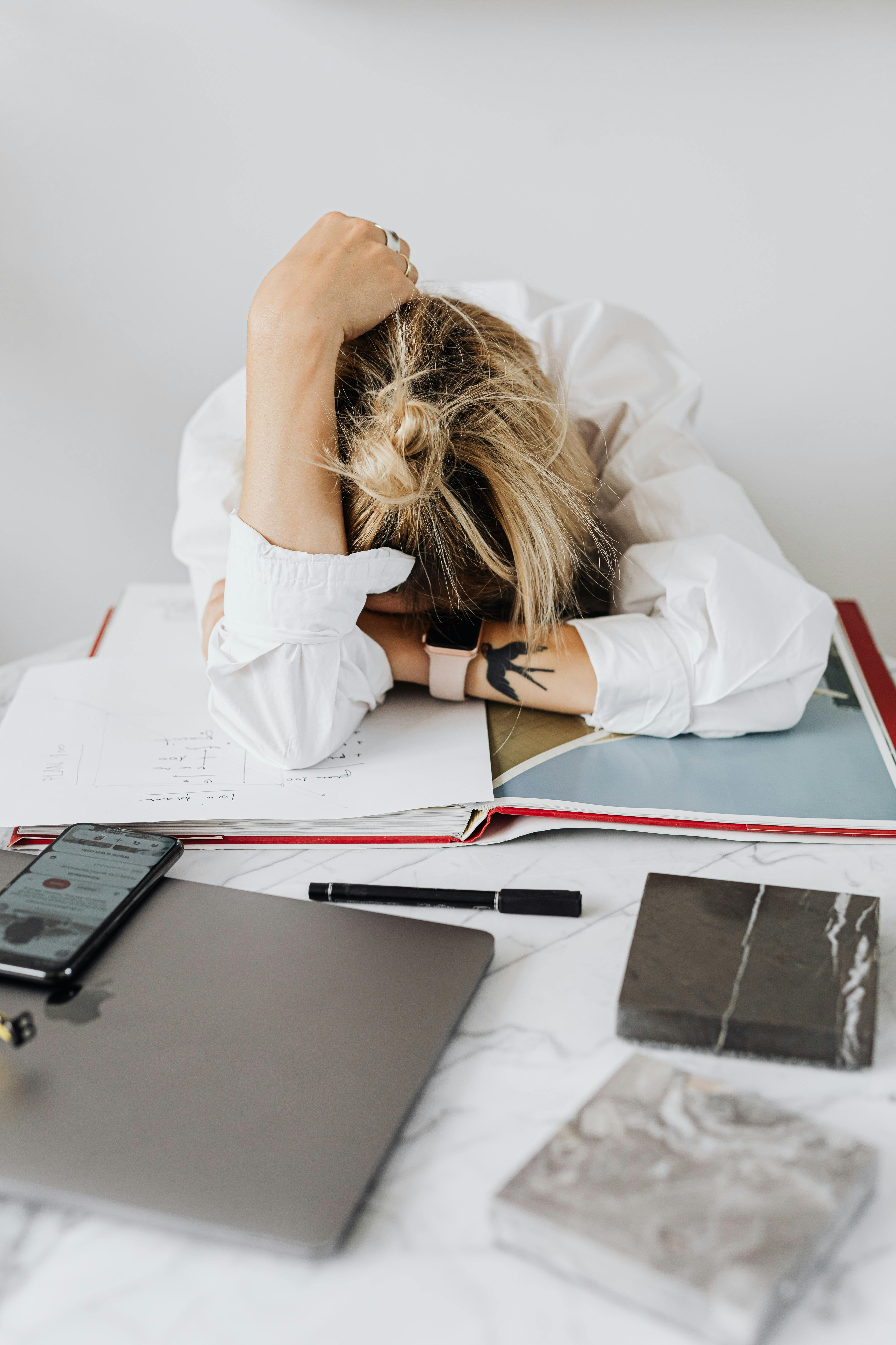 A frustrated woman laying her head on a table | Source: Pexels