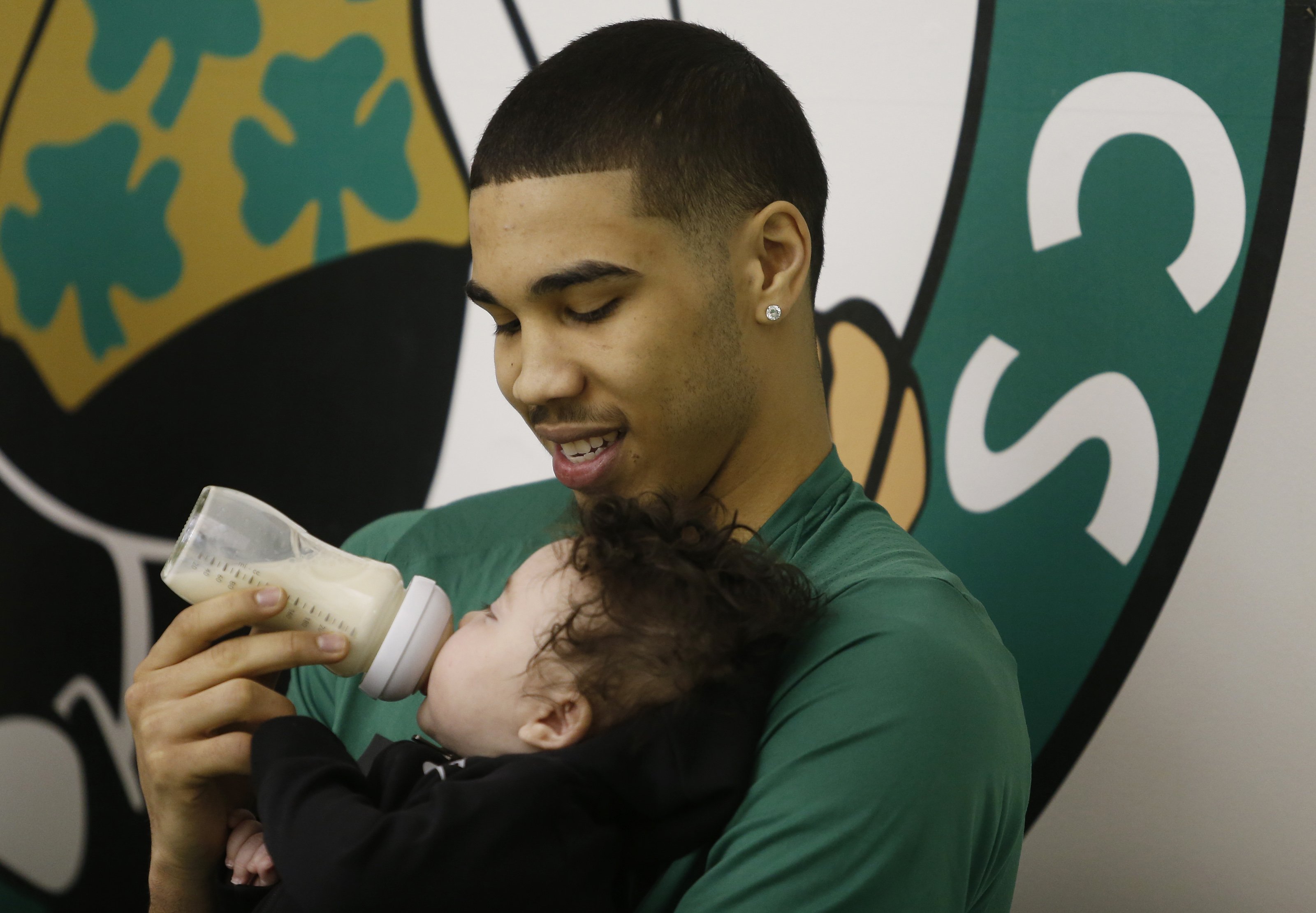 Boston Celtics' Jayson Tatum holds his son Jayson Tatum, Jr. as he takes part in a television interview following Boston Celtics practice in Waltham, MA on April 23, 2018. | Source: Getty Images