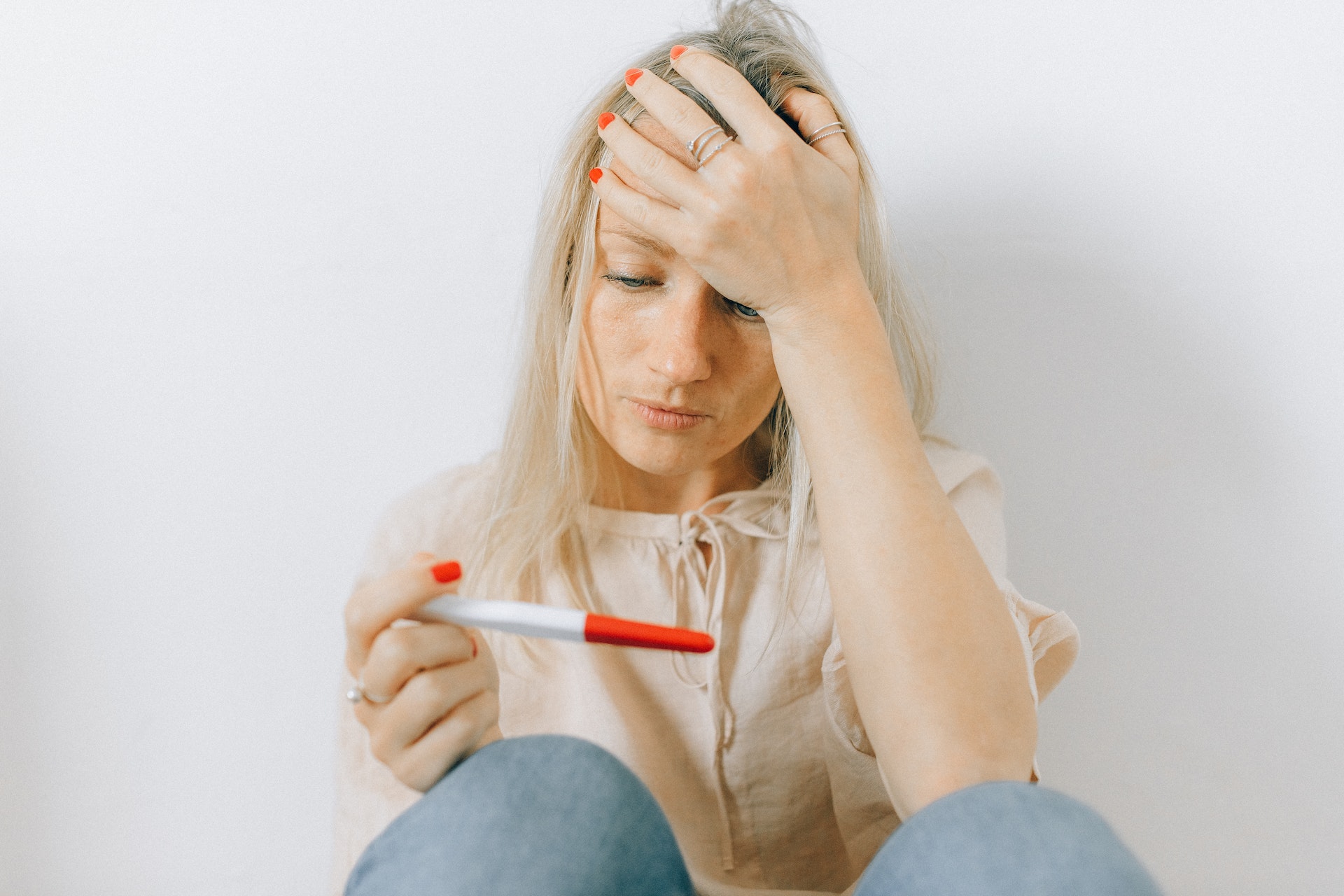 A woman holding a pregnancy testing kit | Source: Pexels